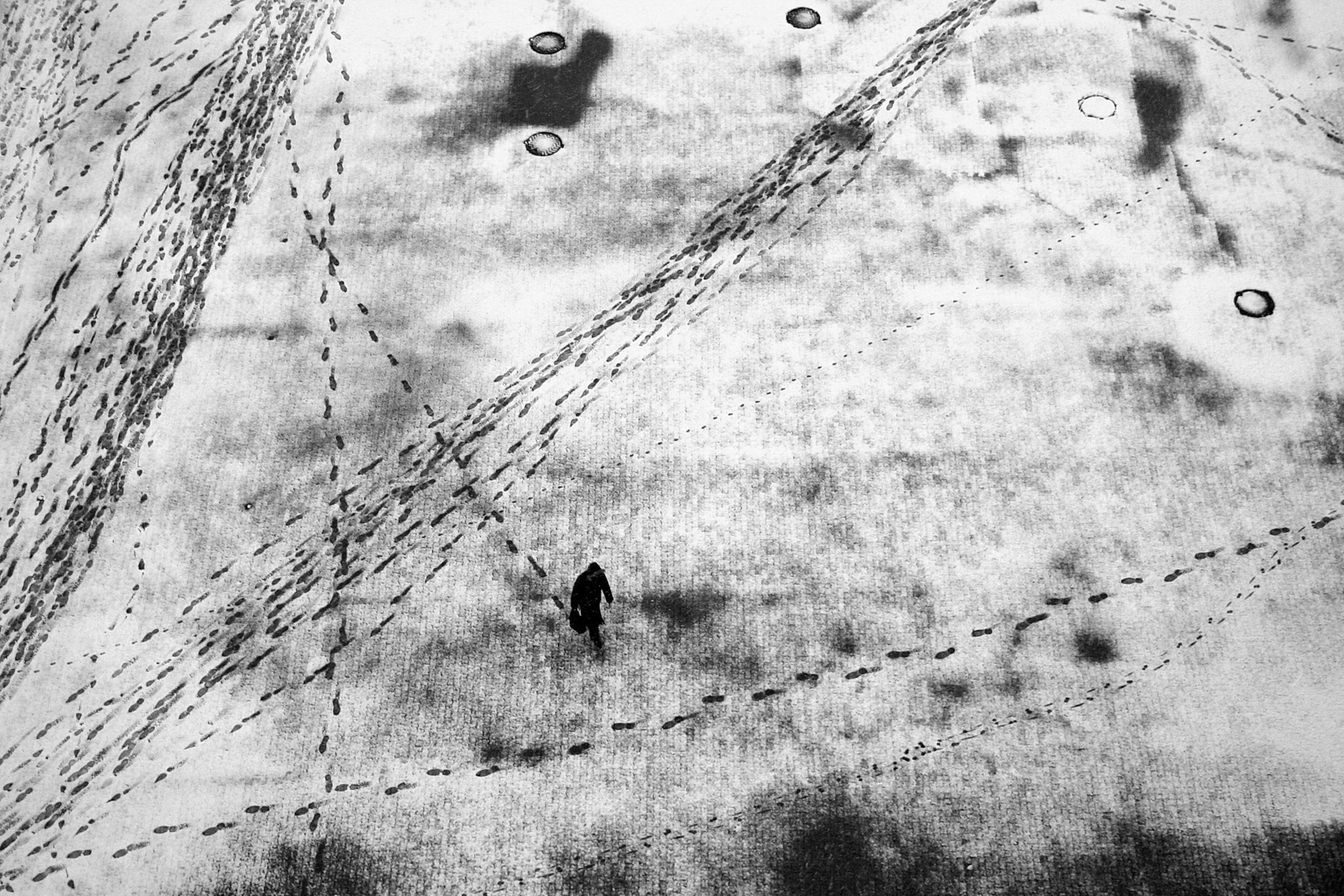 a lone traveler caught in the act of leaving footprints