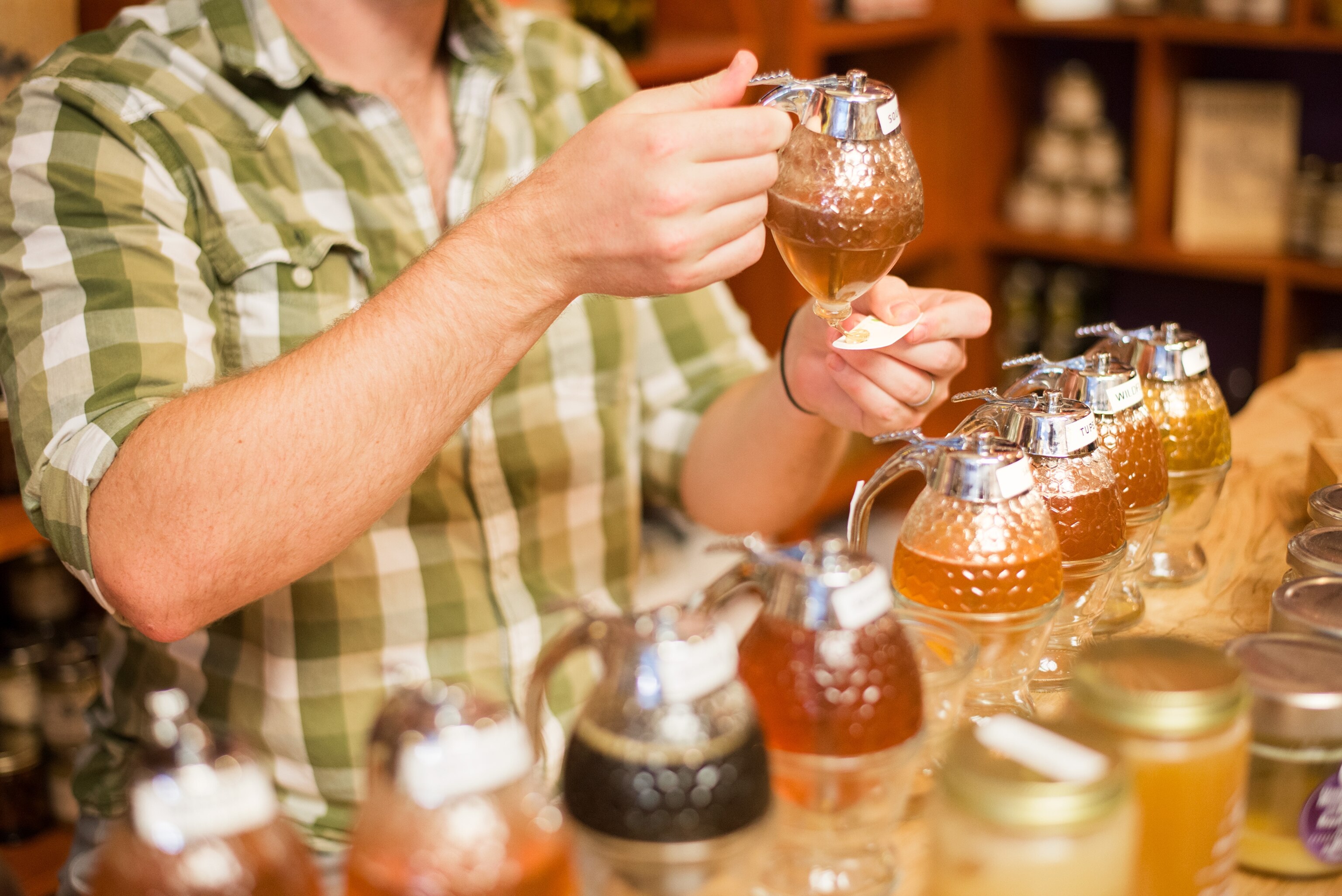 a man handing out honey samples at the Asheville Bee Charmer in Asheville, North Carolina