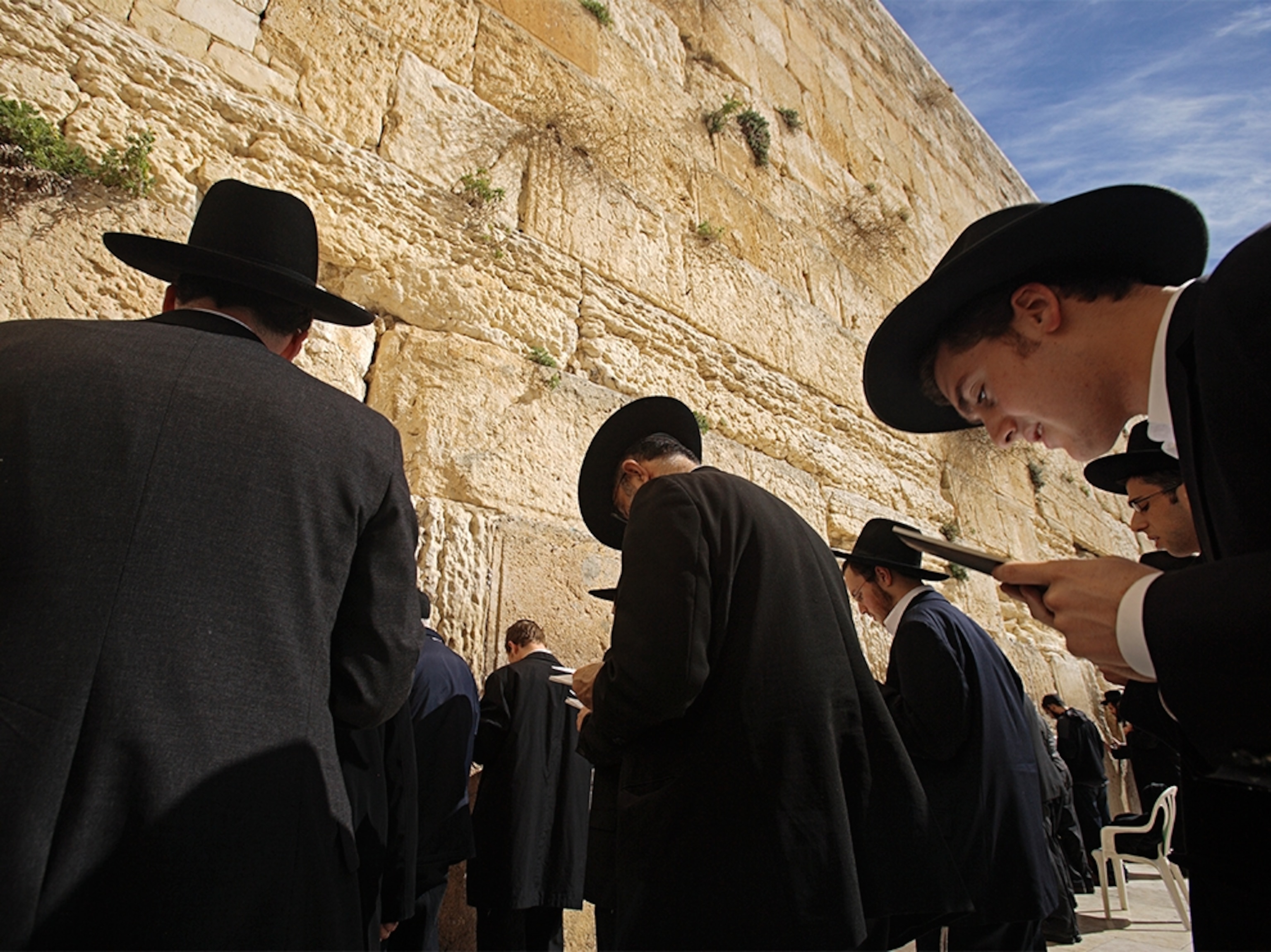 people praying outside the Western Wall in Jerusalem