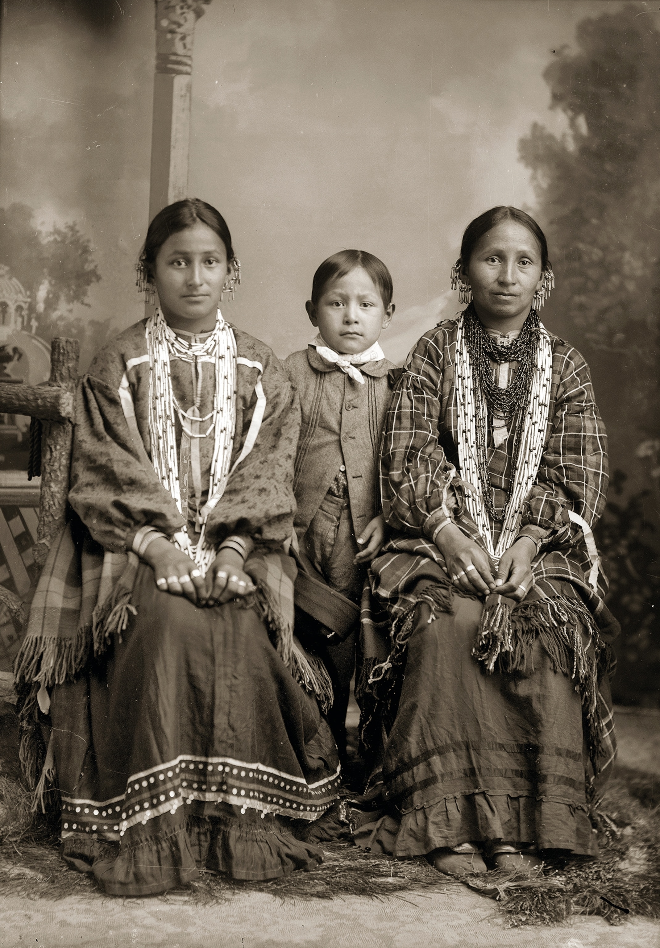 Studio portrait of two Ho-Chunk women and a young boy.
