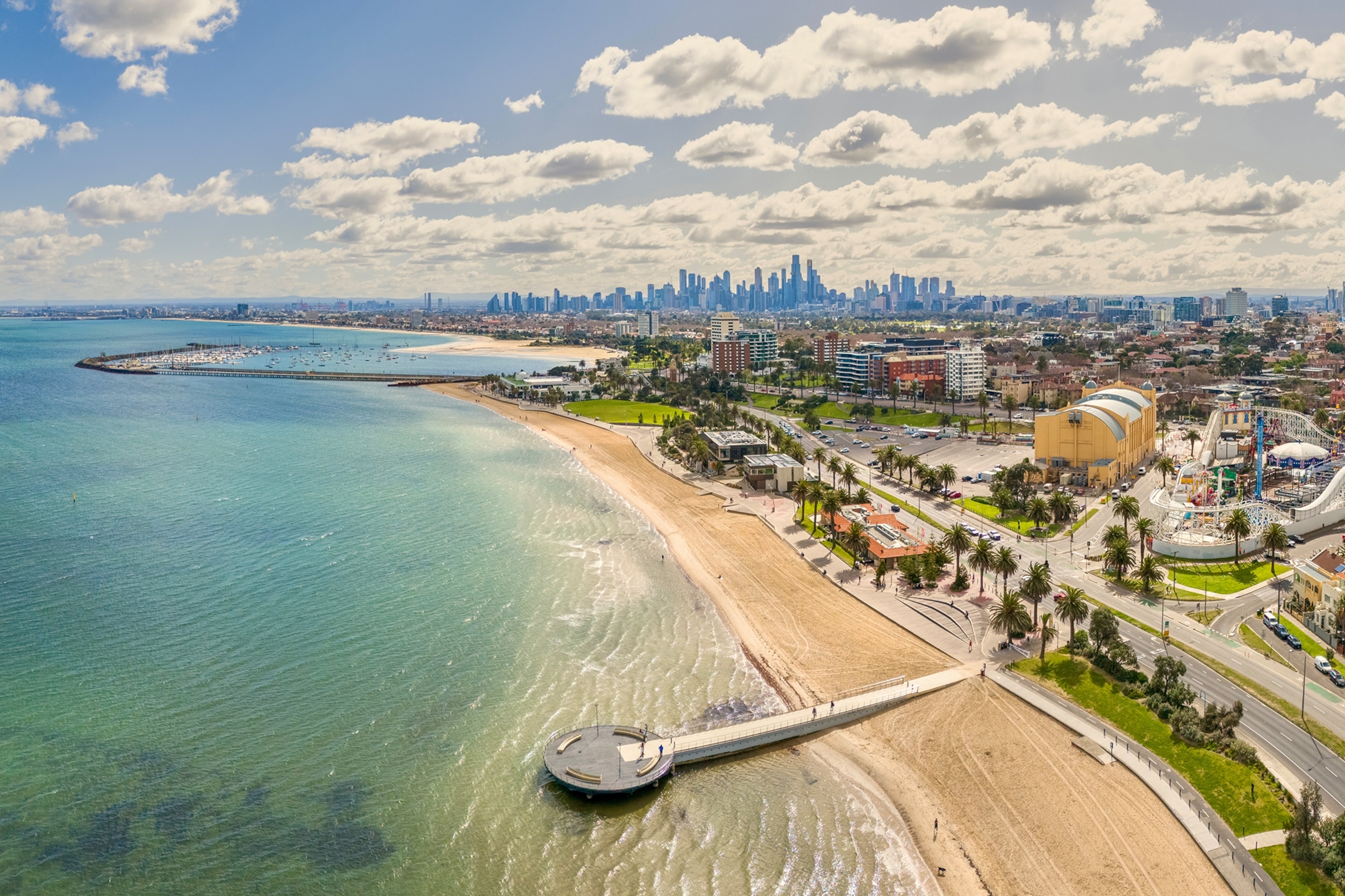 An ariel view of a city's beachfront with the skyline in the background.