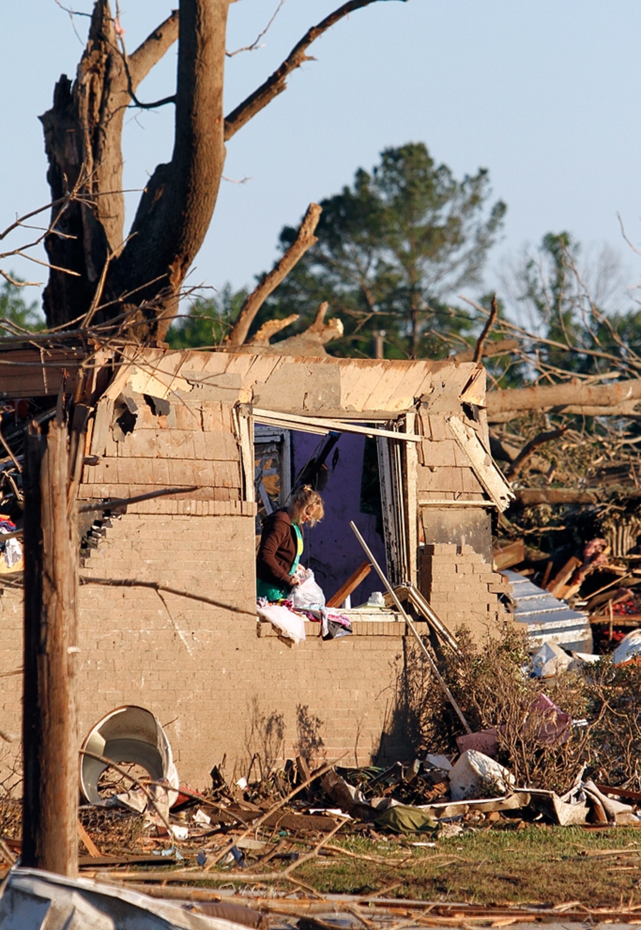 Alabama tornado picture: a woman searching house remains after a tornado that made Alabama news headlines