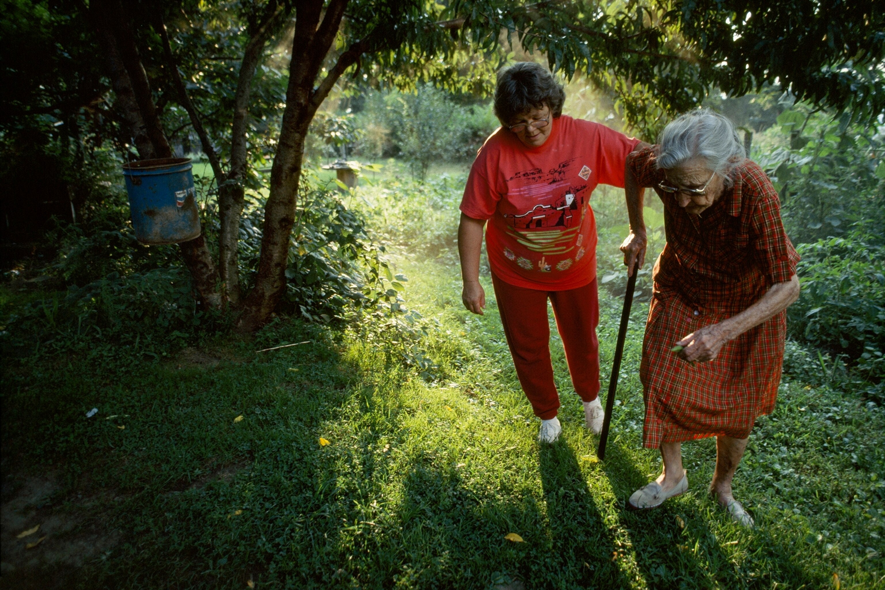 Juanita Wright helps her mother-in-law Lula down to the garden