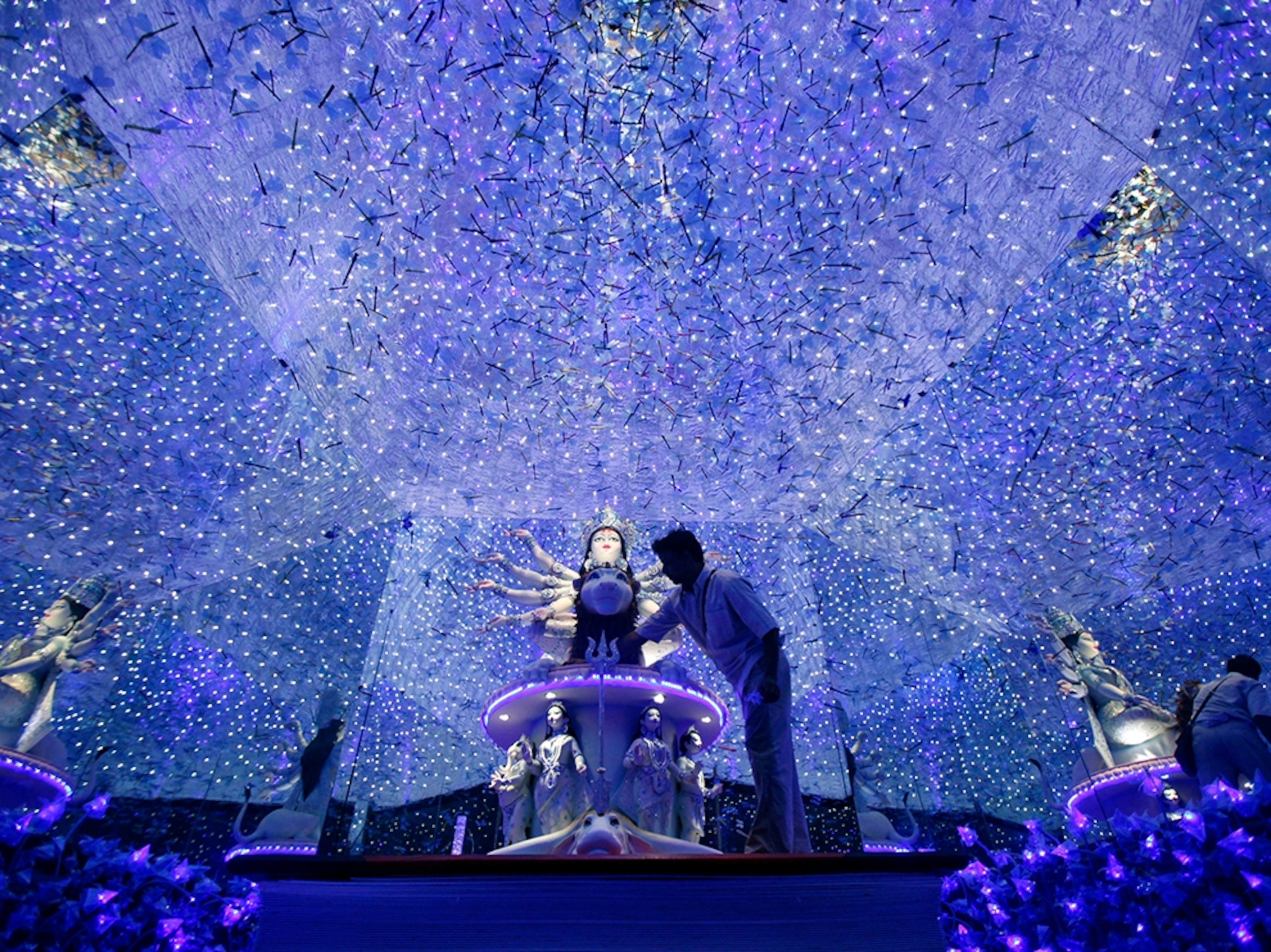 a man preparing a display of lights for the Durga Puja Festival, India