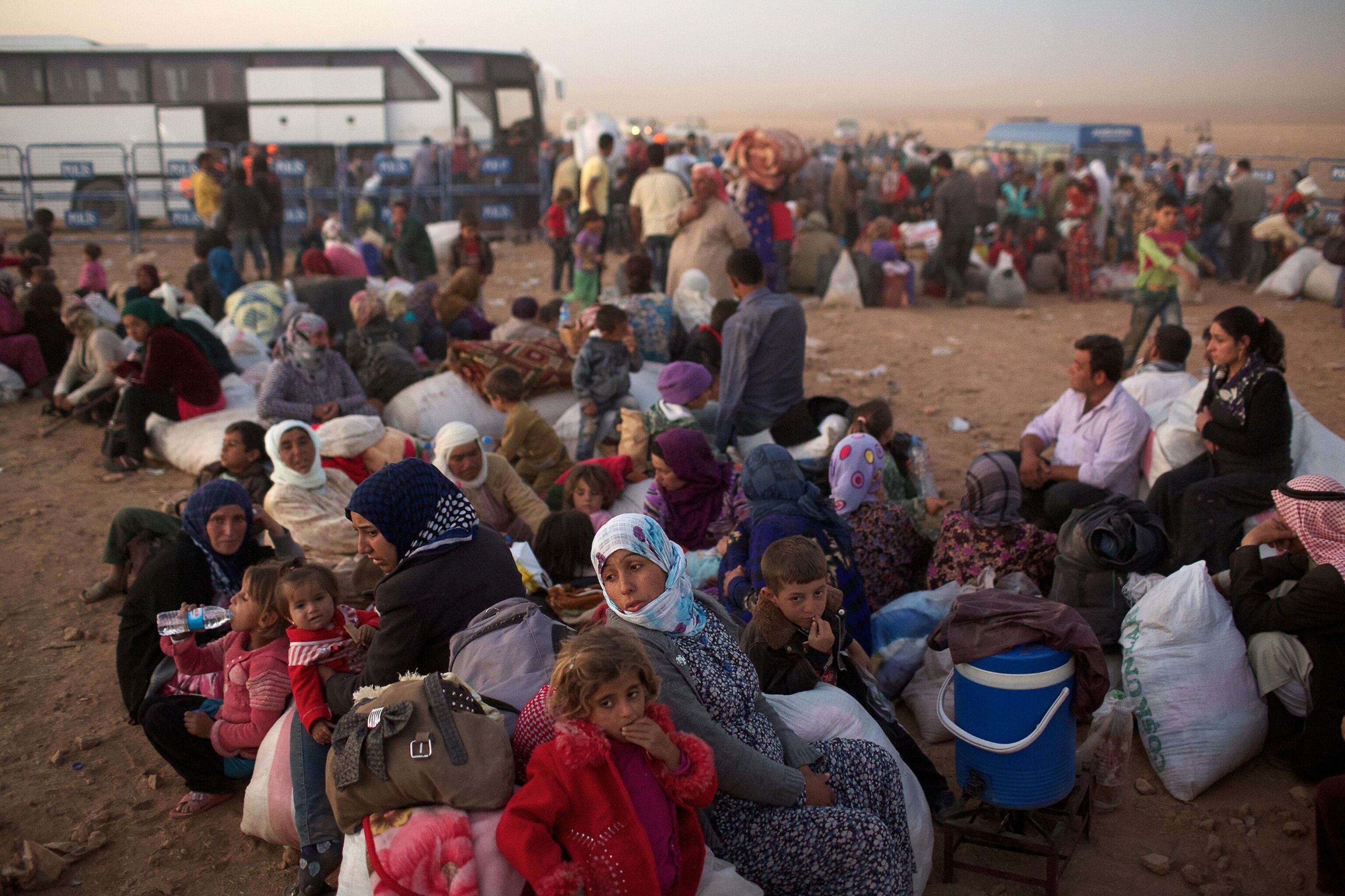 a Syrian women carrying a baby after fleeing to Turkey with thousands of others.