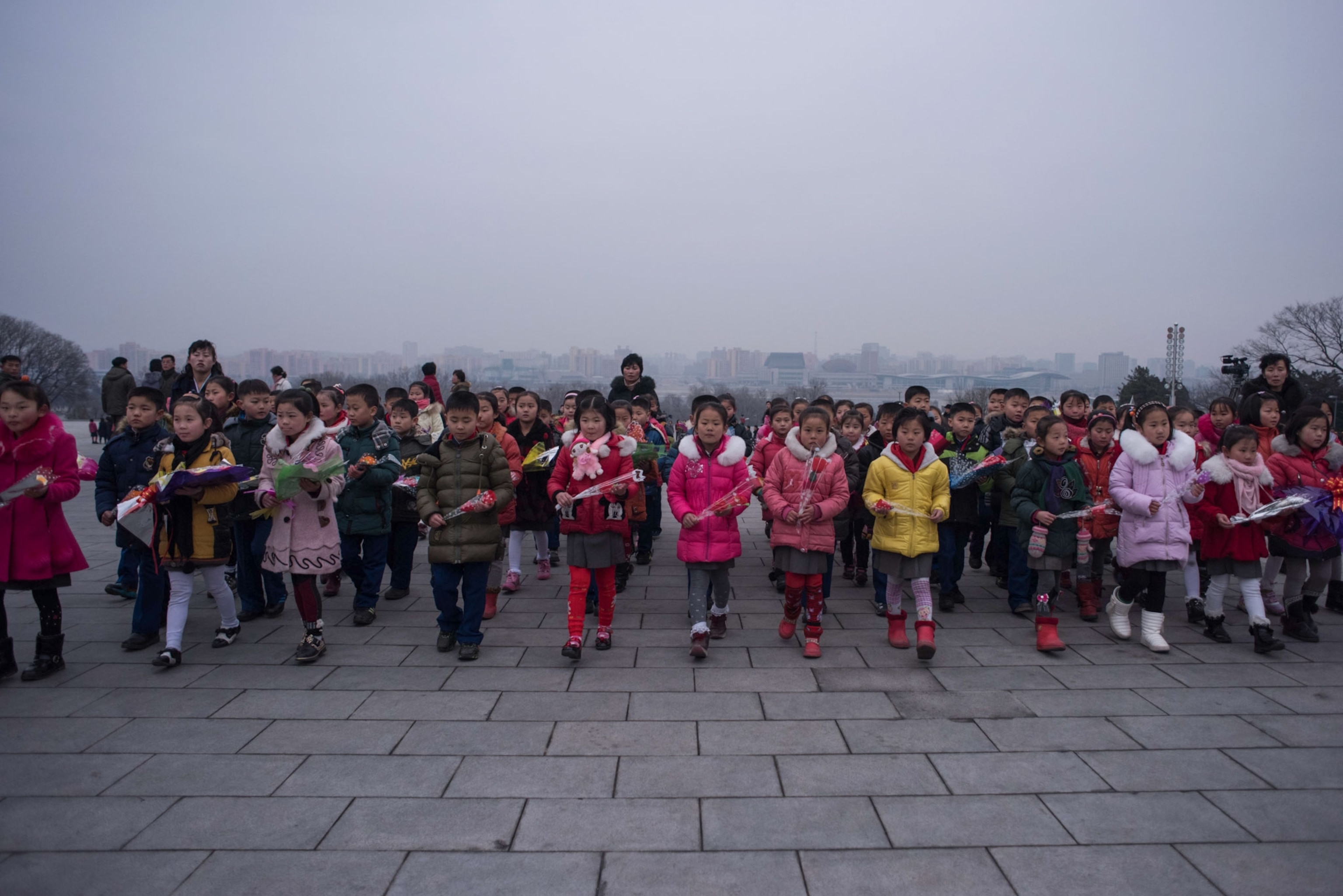 a group of children holding flowers in North Korea