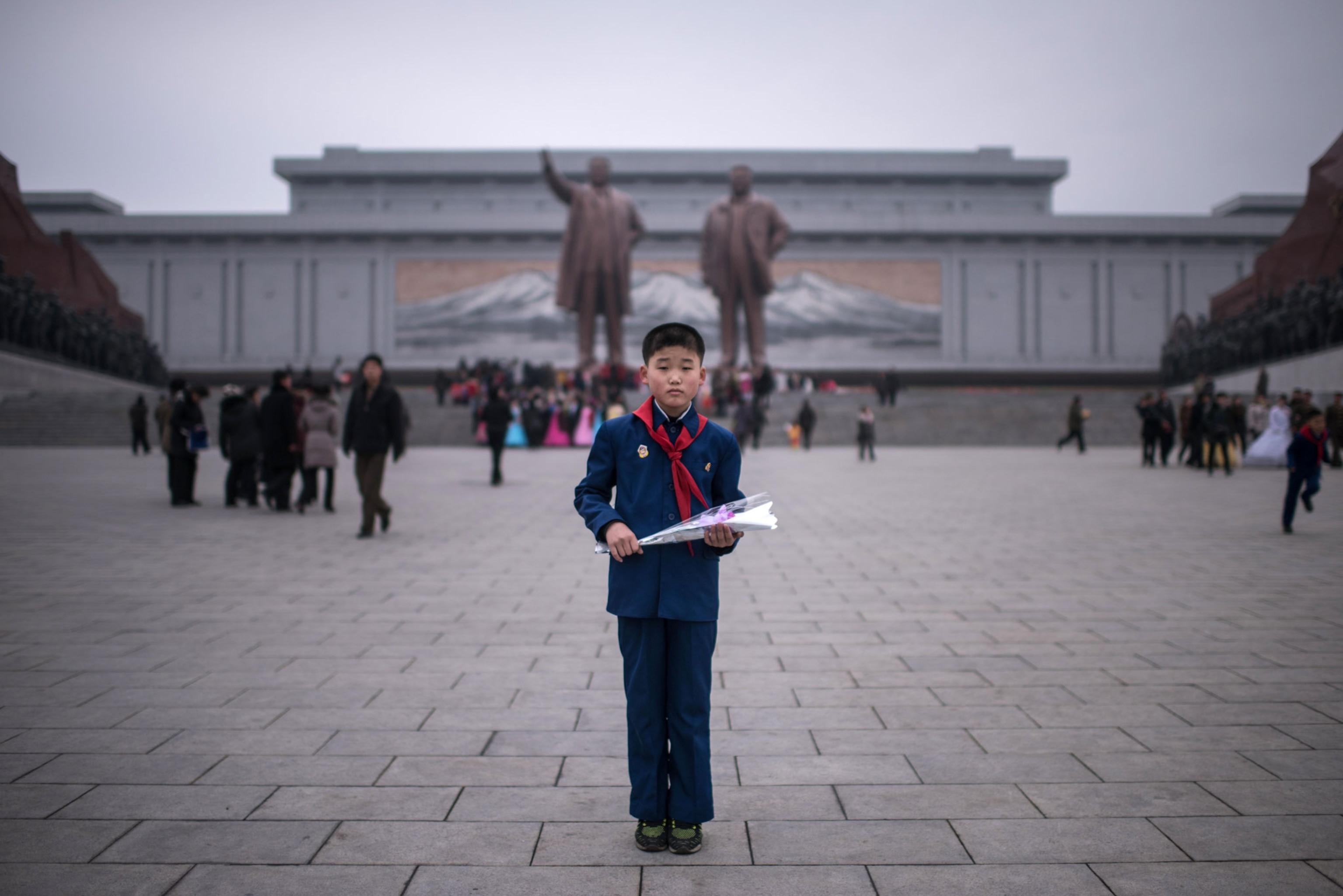 a boy holding a flower in North Korea
