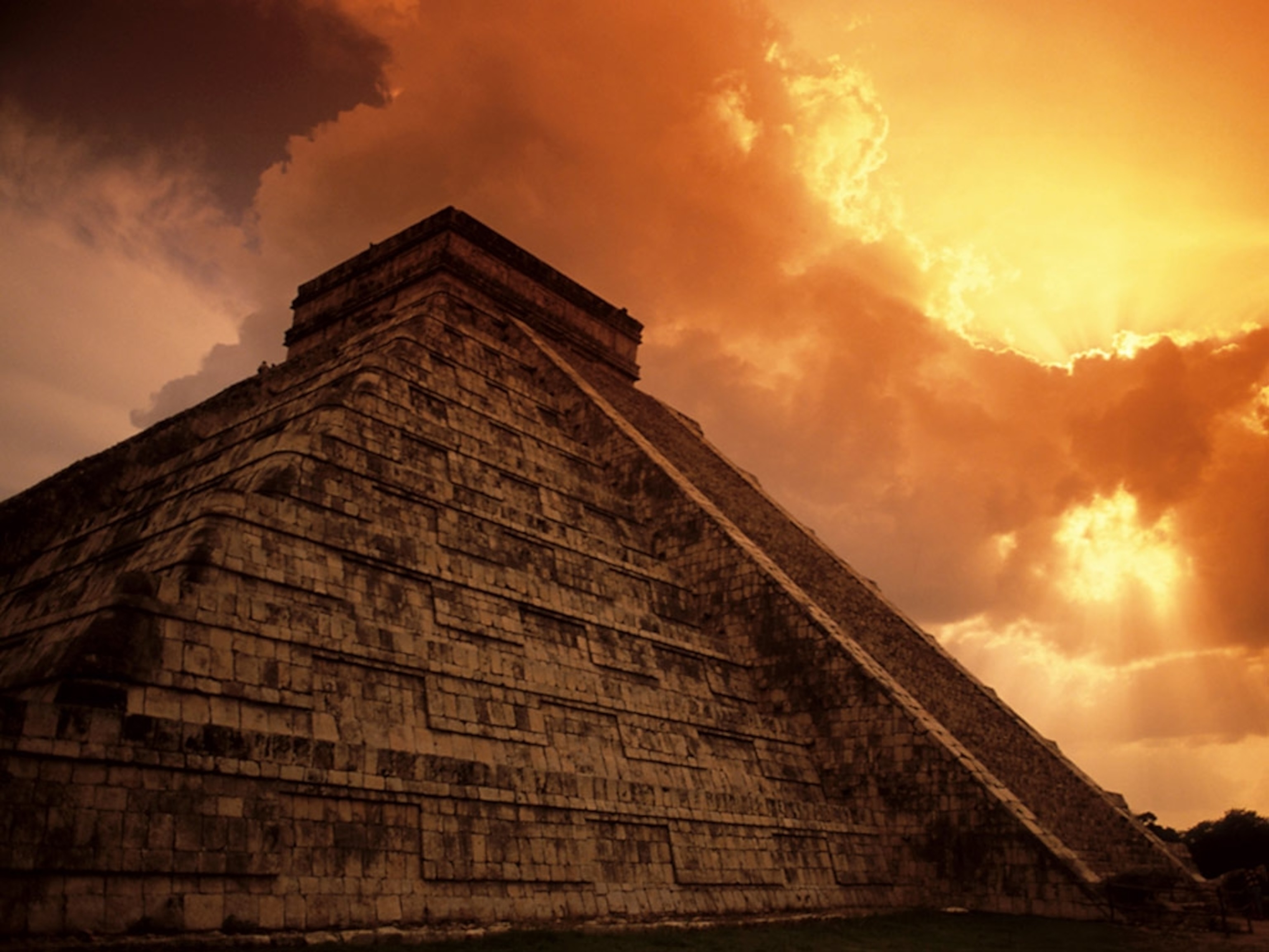A pyramid beneath sunburst clouds