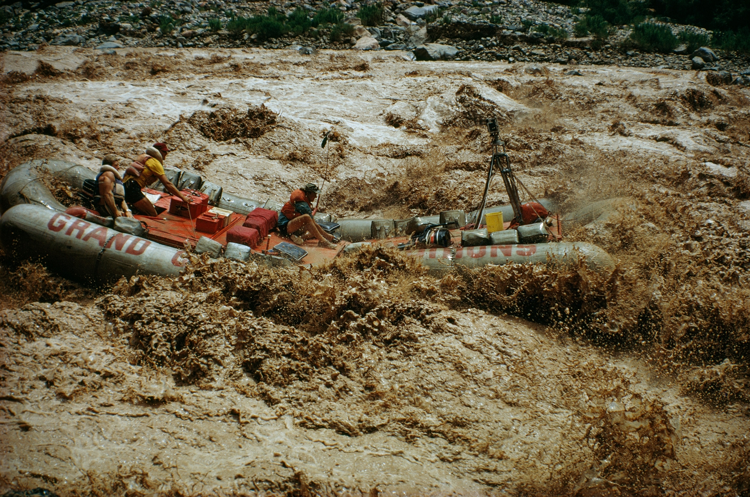 Tourists bounce through Lava Falls Rapids in neoprene raft.