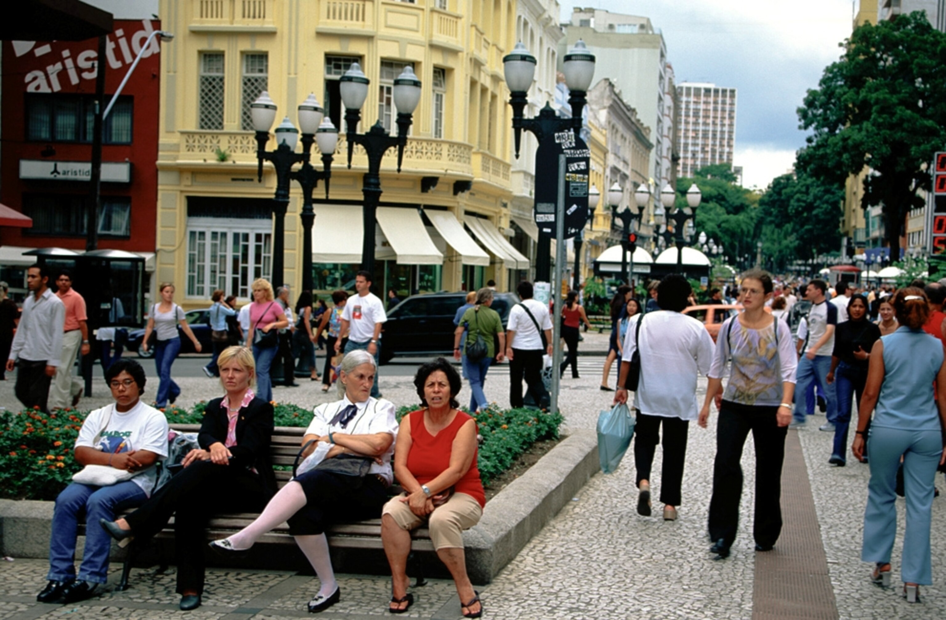 People lounge in a plaza in Curitiba, Brazil
