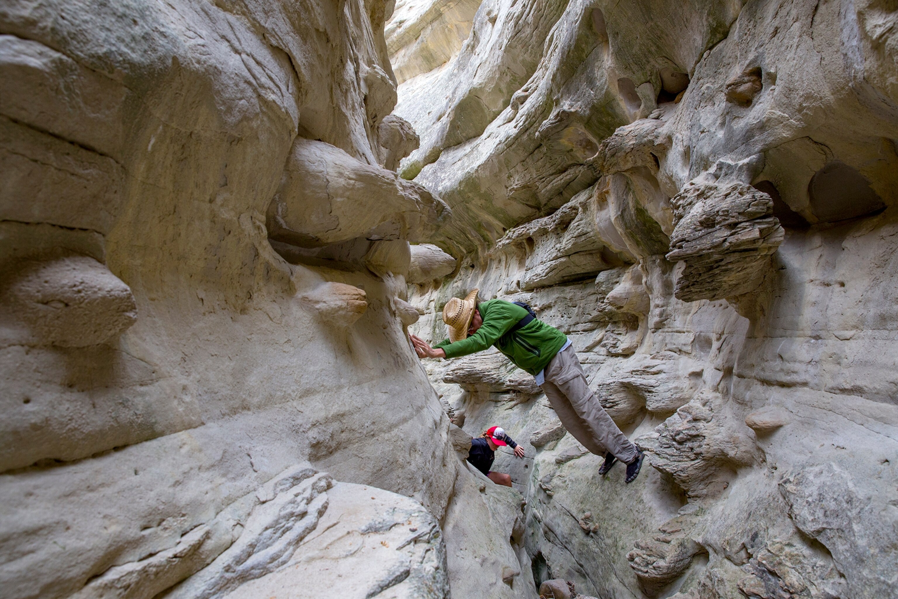 a guide leading a hiker through the Neat Coulee slot canyon in Montana