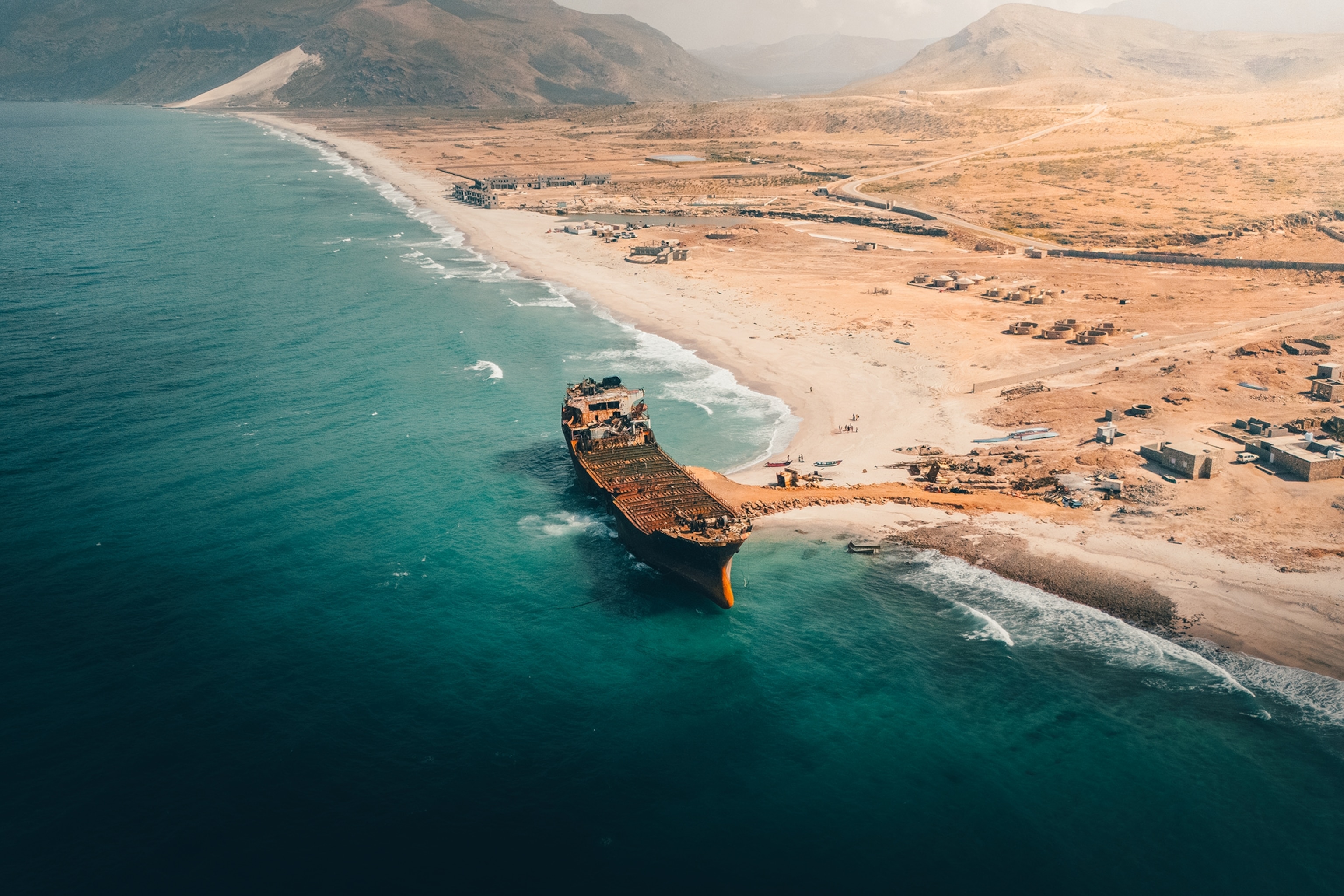 A cargo shipwreck stranded on the edge of a beach in Yemen.