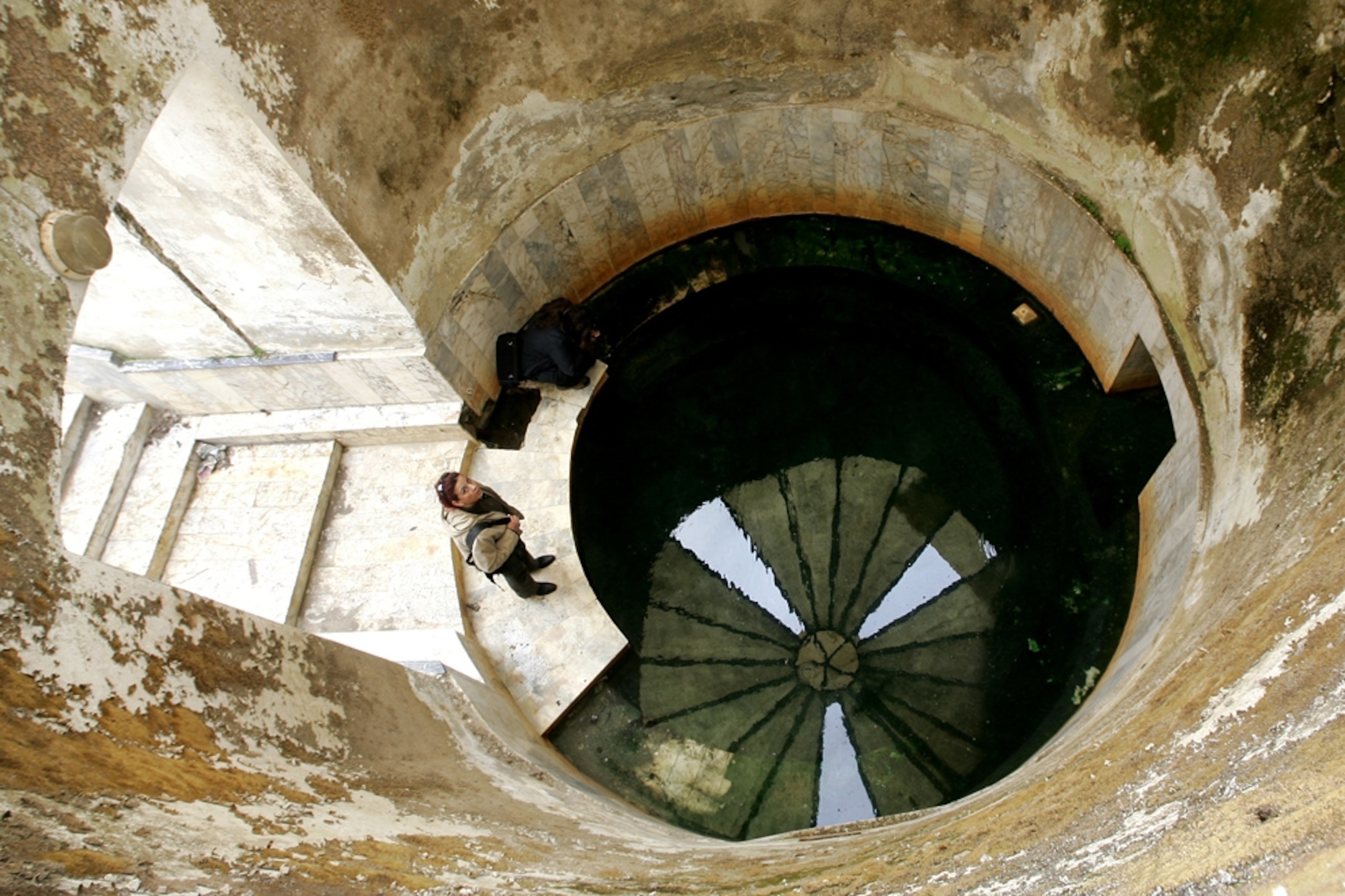 A woman visits a well-like water source in the Roman ruins at Allianoi.