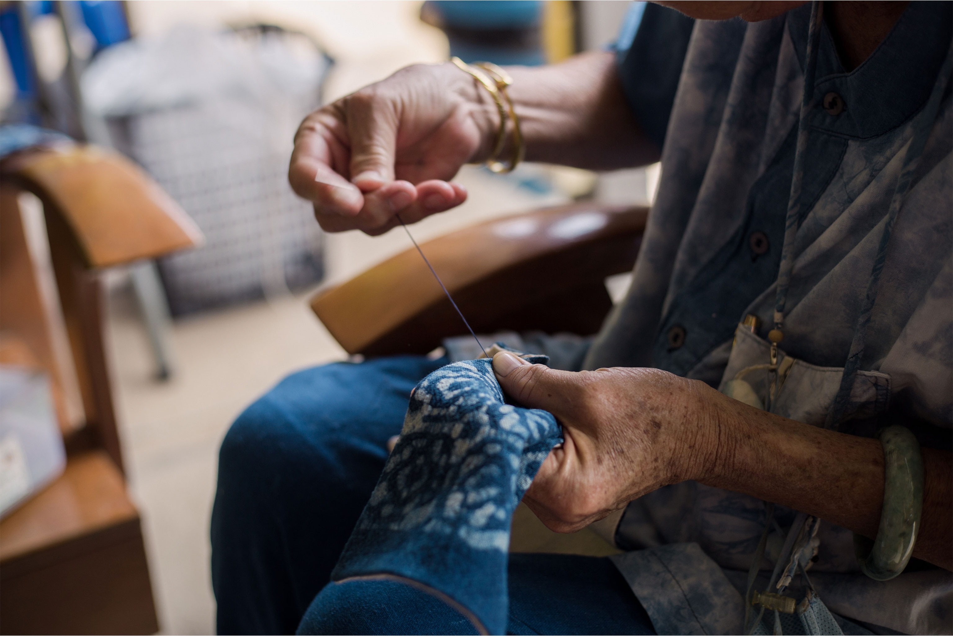 Auntie Ngeam's hands busy with needlework.