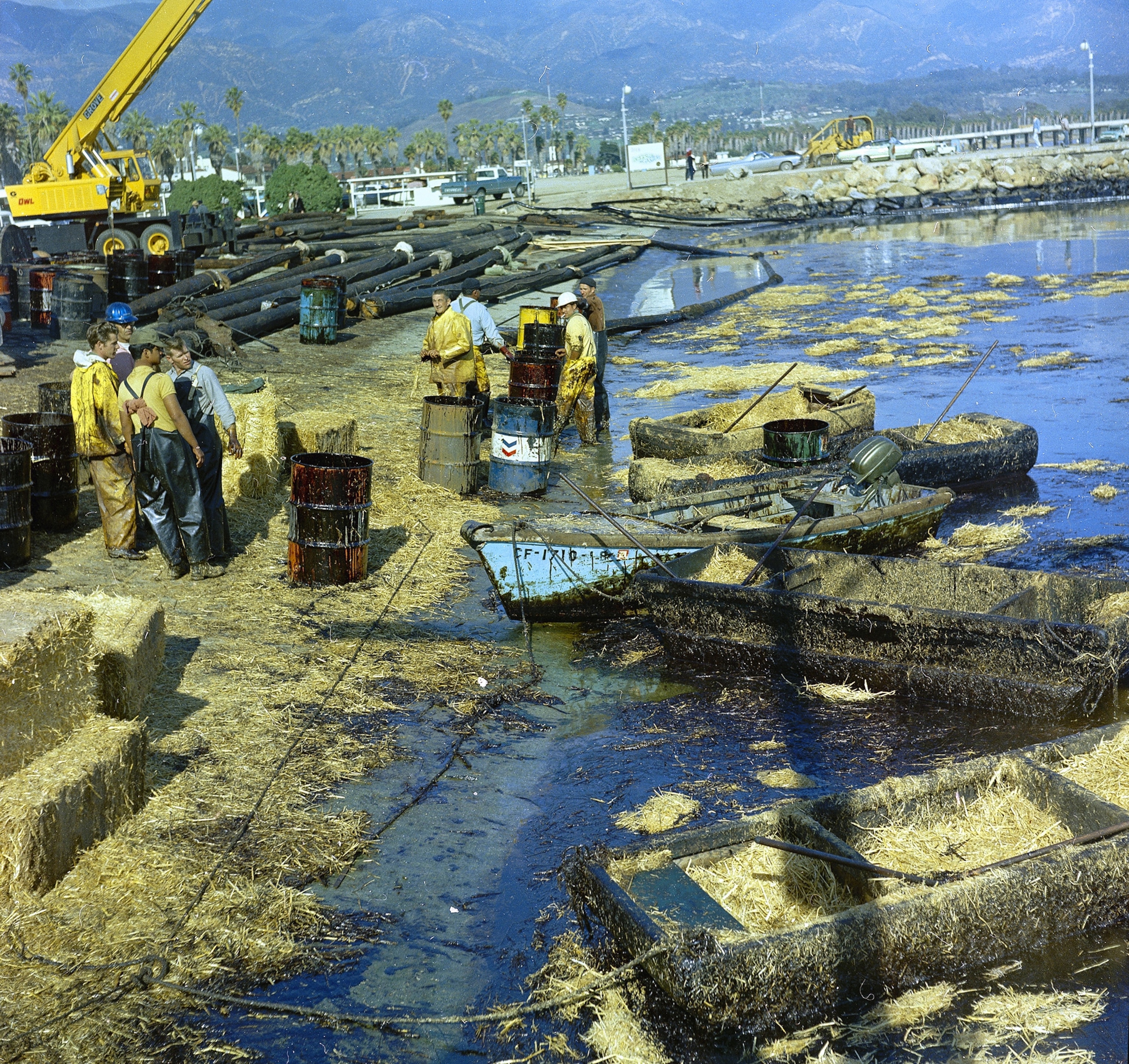 workers cleaning up oil-soaked straw from at Santa Barbara Harbor, Calif., in 1969