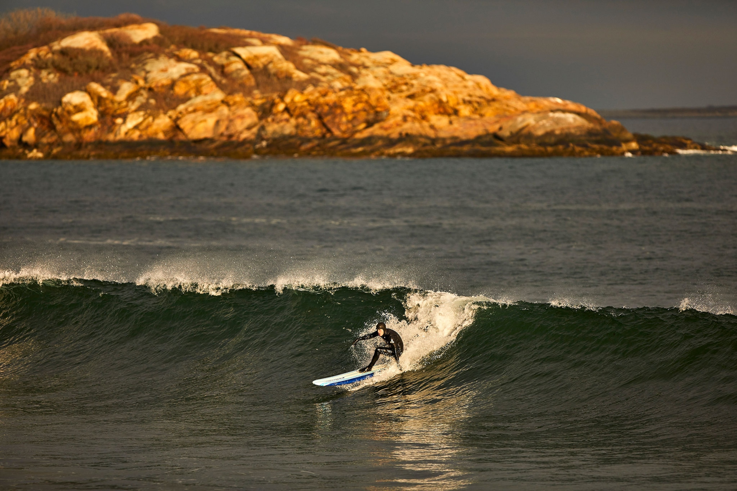 a surfer at Good Harbor Beach in Gloucester, Massachusetts