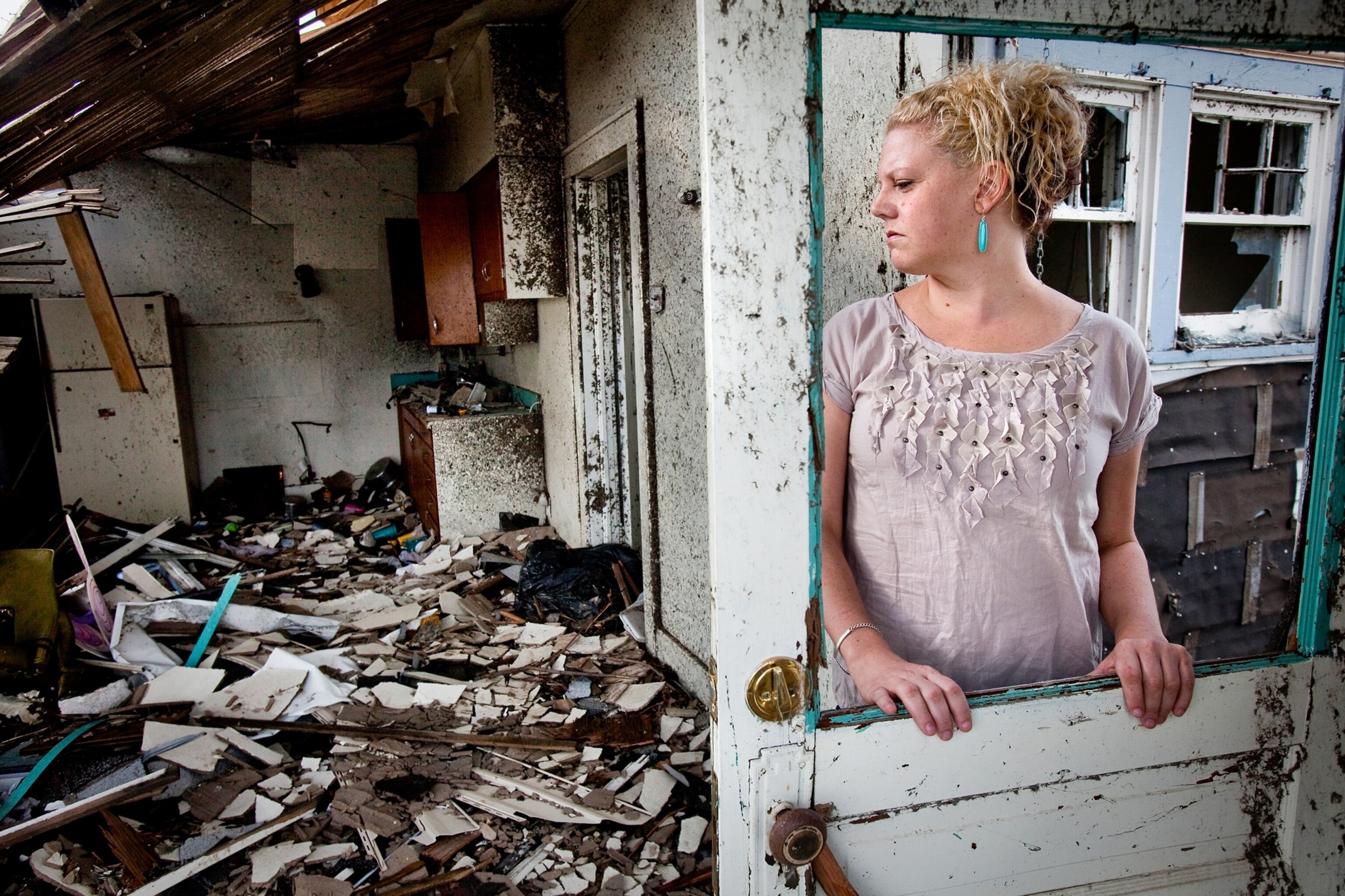 How Joplin Recovered - A woman stands in the doorway of her home that was destroyed by a tornado.