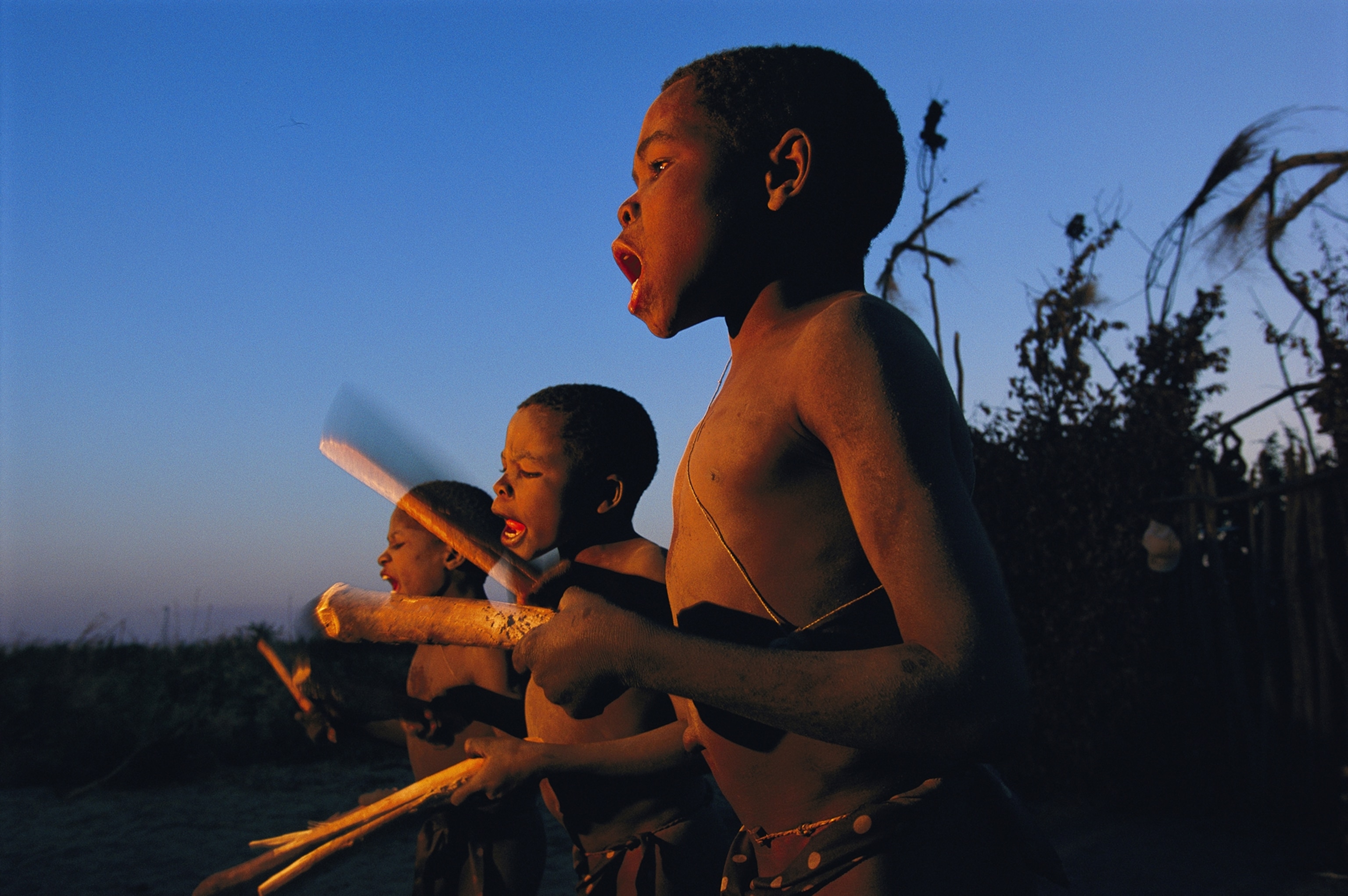 Newly circumcised boys from the Luvale tribe greet the dawn with traditional songs and drumming.