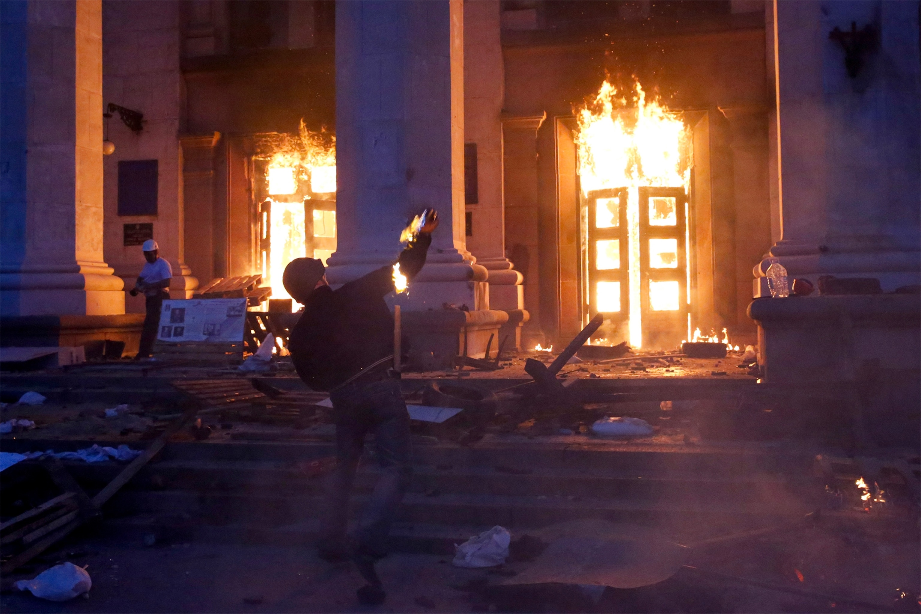 a pro-Russian activist aiming a pistol at supporters of the Kiev government.