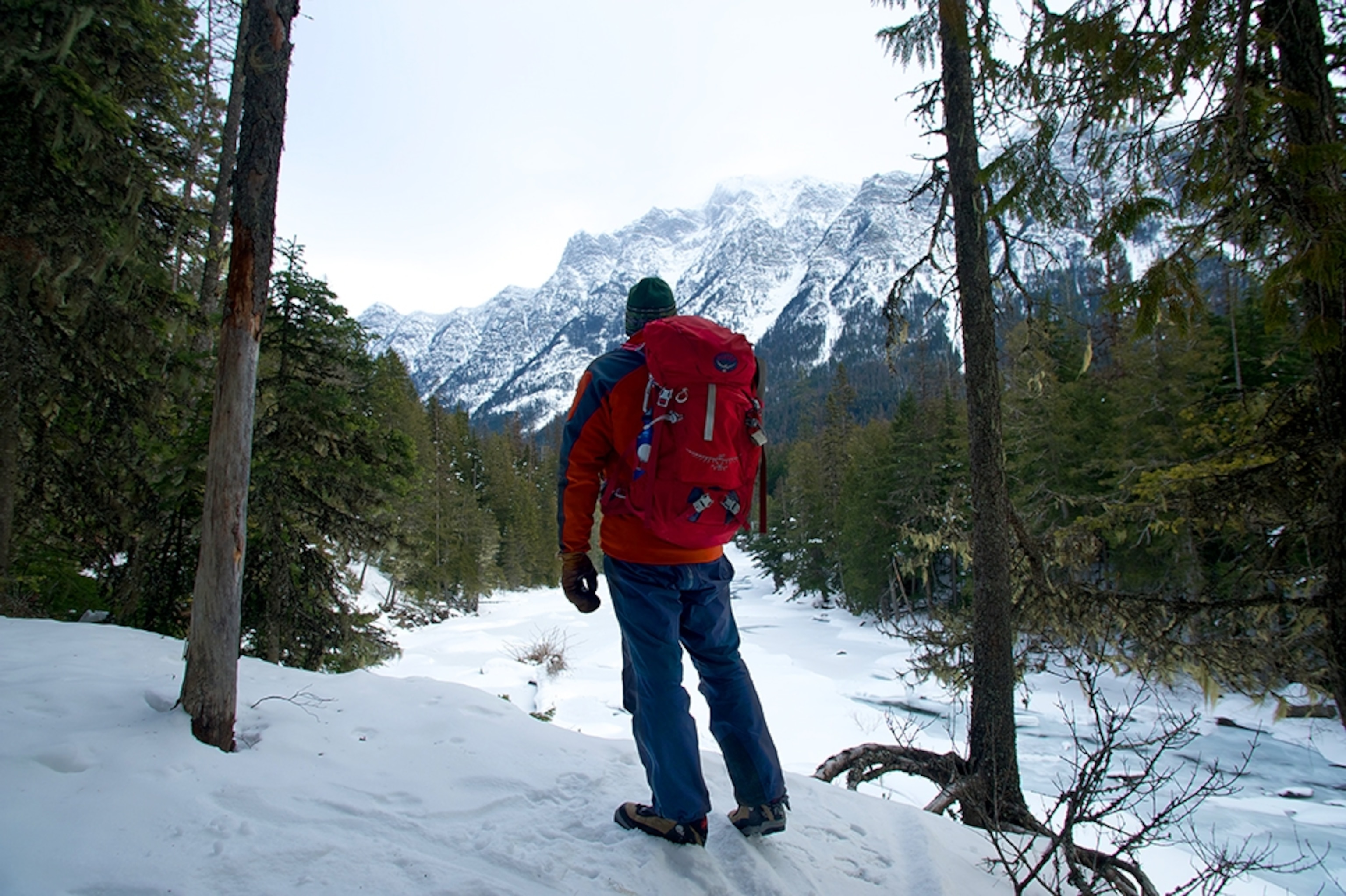 a man hiking in snow in Glacier National Park