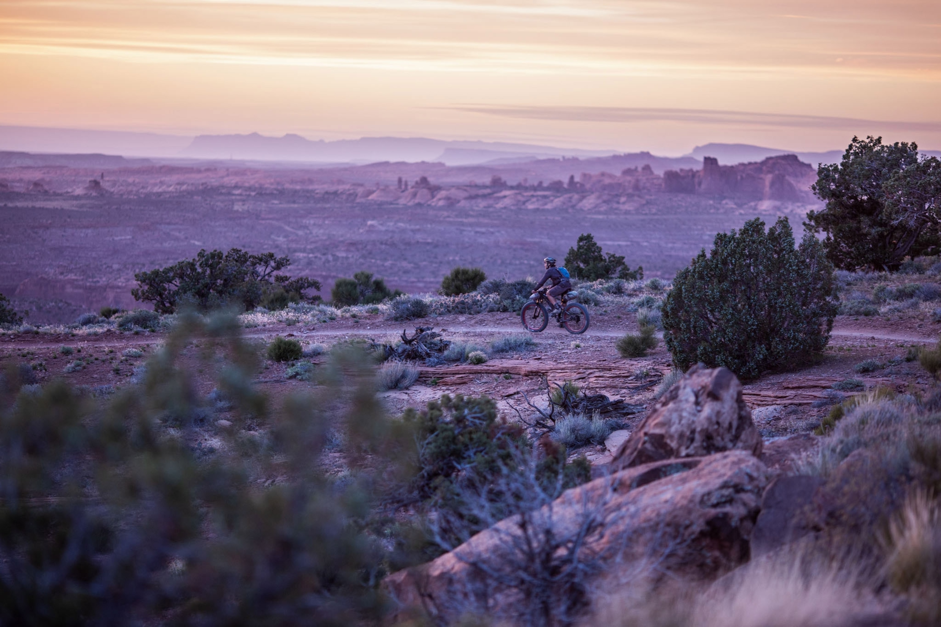 a bike rider in the sunset racing into Moab from the Kokopelli Trail in Utah