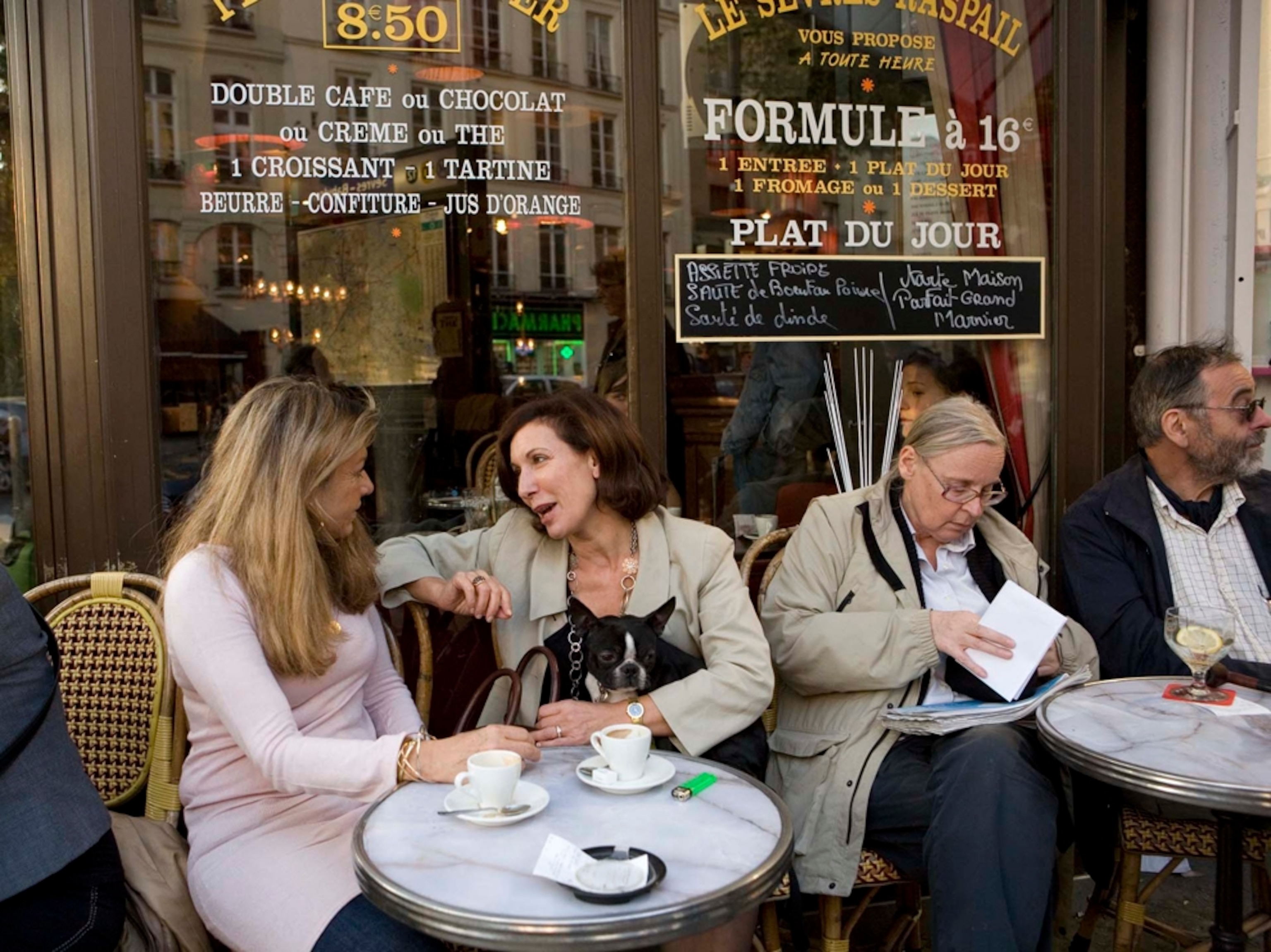 Women chat outside cafe in Paris, France