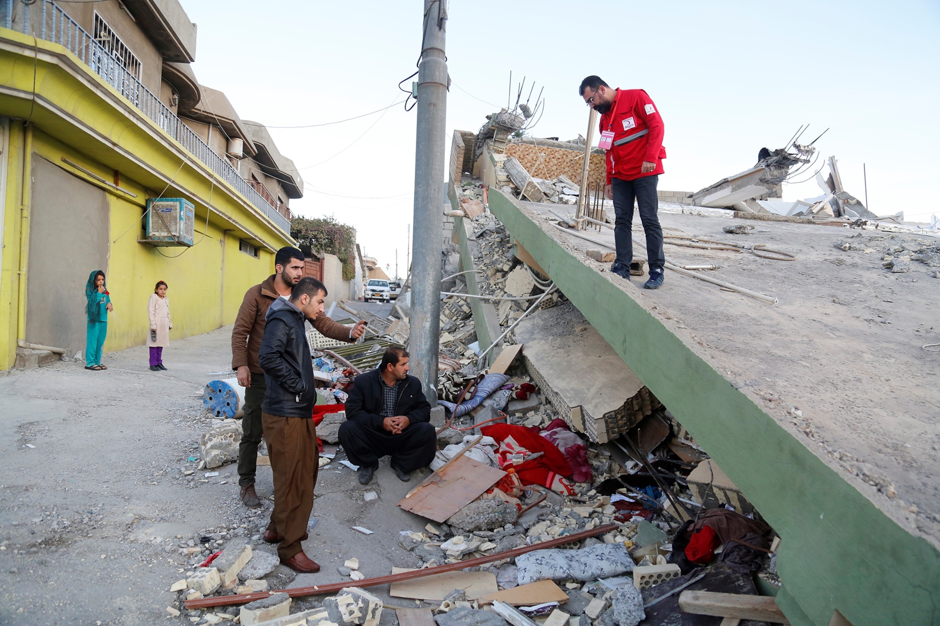 people examining a destroyed building