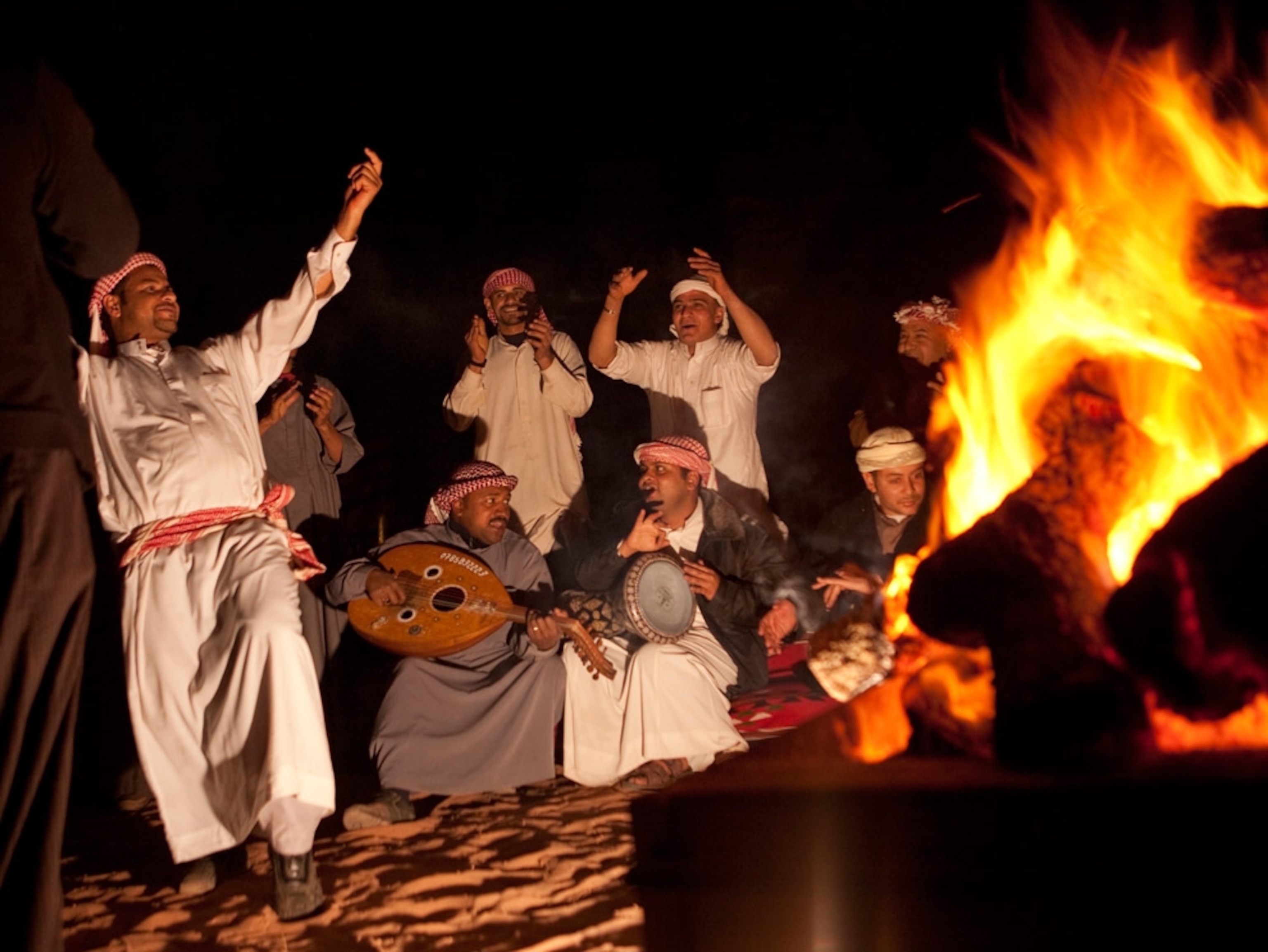 Men singing and dancing around a fire