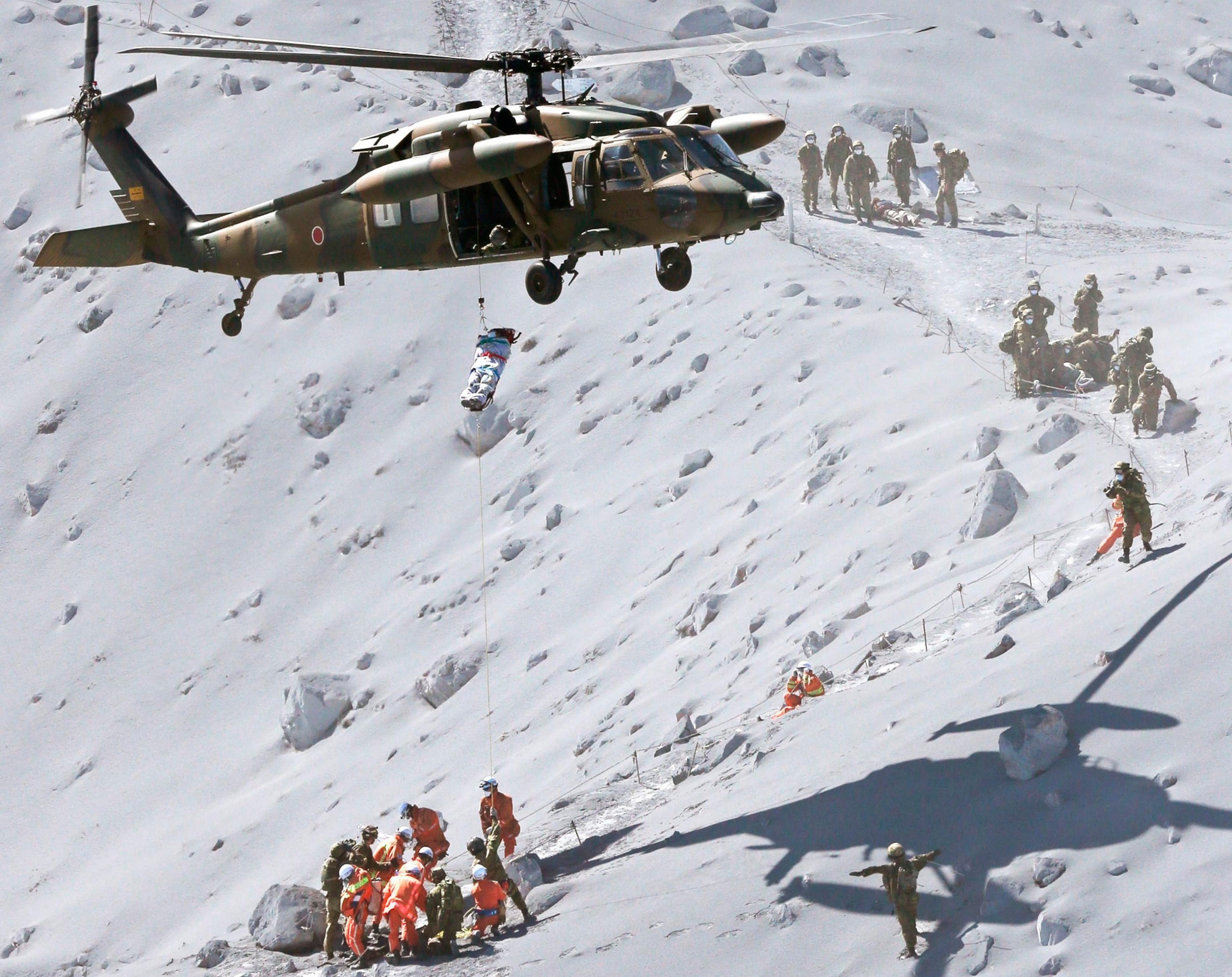 a hiker being lifted by a rescue helicopter of Japan Self-Defense Force (JSDF).