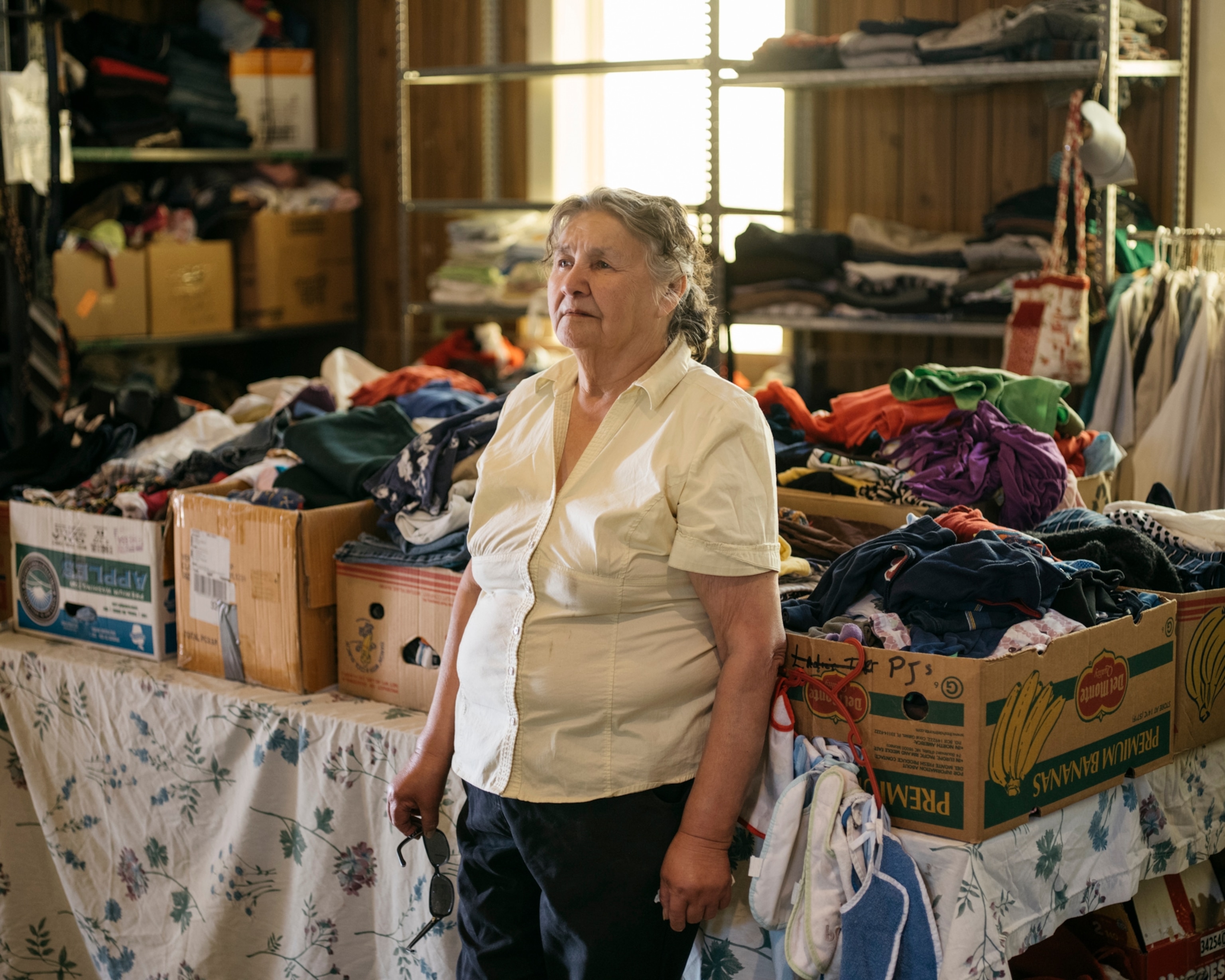 a woman standing among boxes of clothing in a building in Alberta, Canada