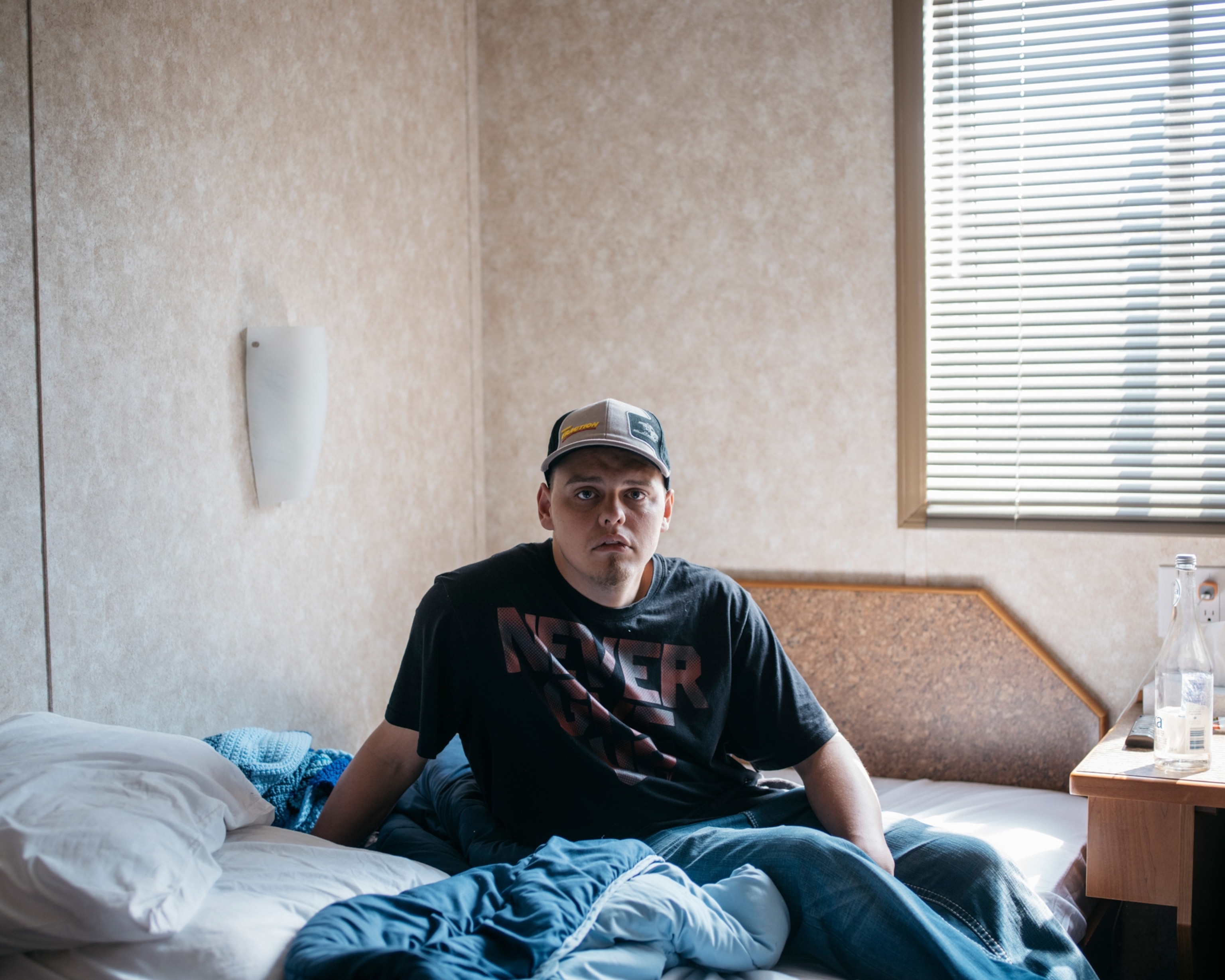 young man sitting on bed