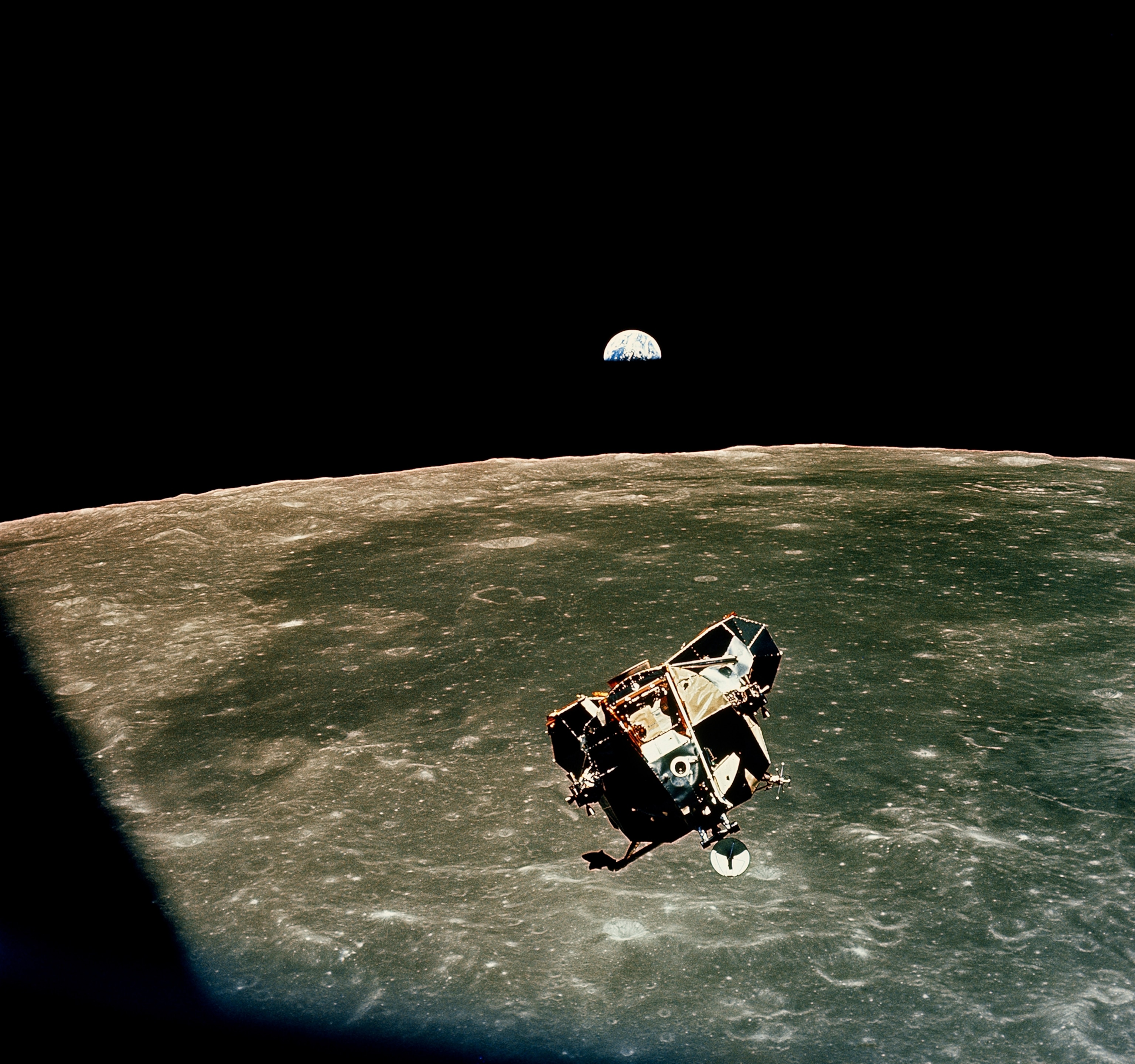 Riding to rendezvous with a half earth in sight, Armstrong and Aldrin guide Eagle to its docking with Columbia. "Absolutely beautiful," said Collins. The eastern rim of the moon lies 70 miles below.