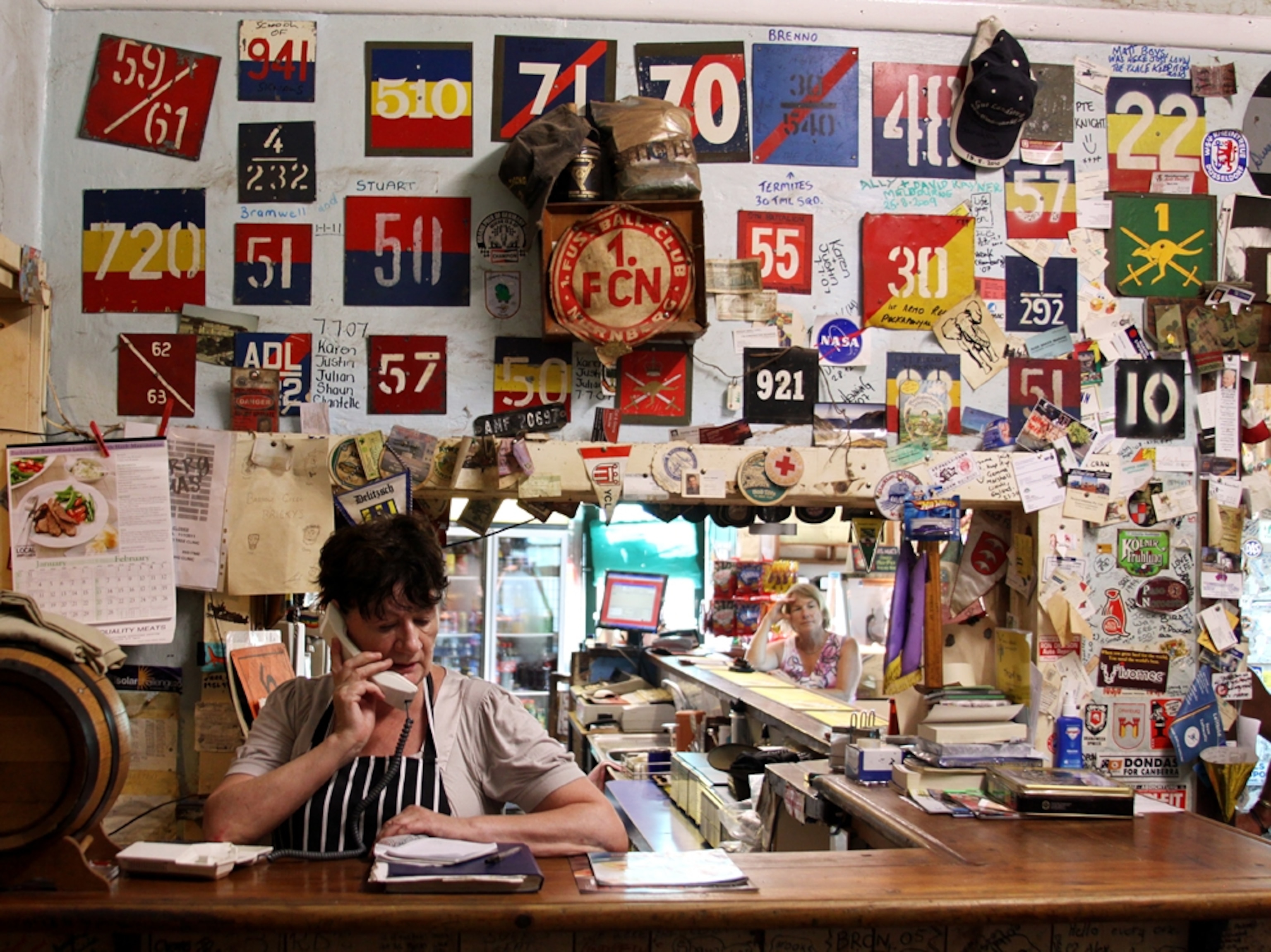 Woman on phone in bar with decor on the wall
