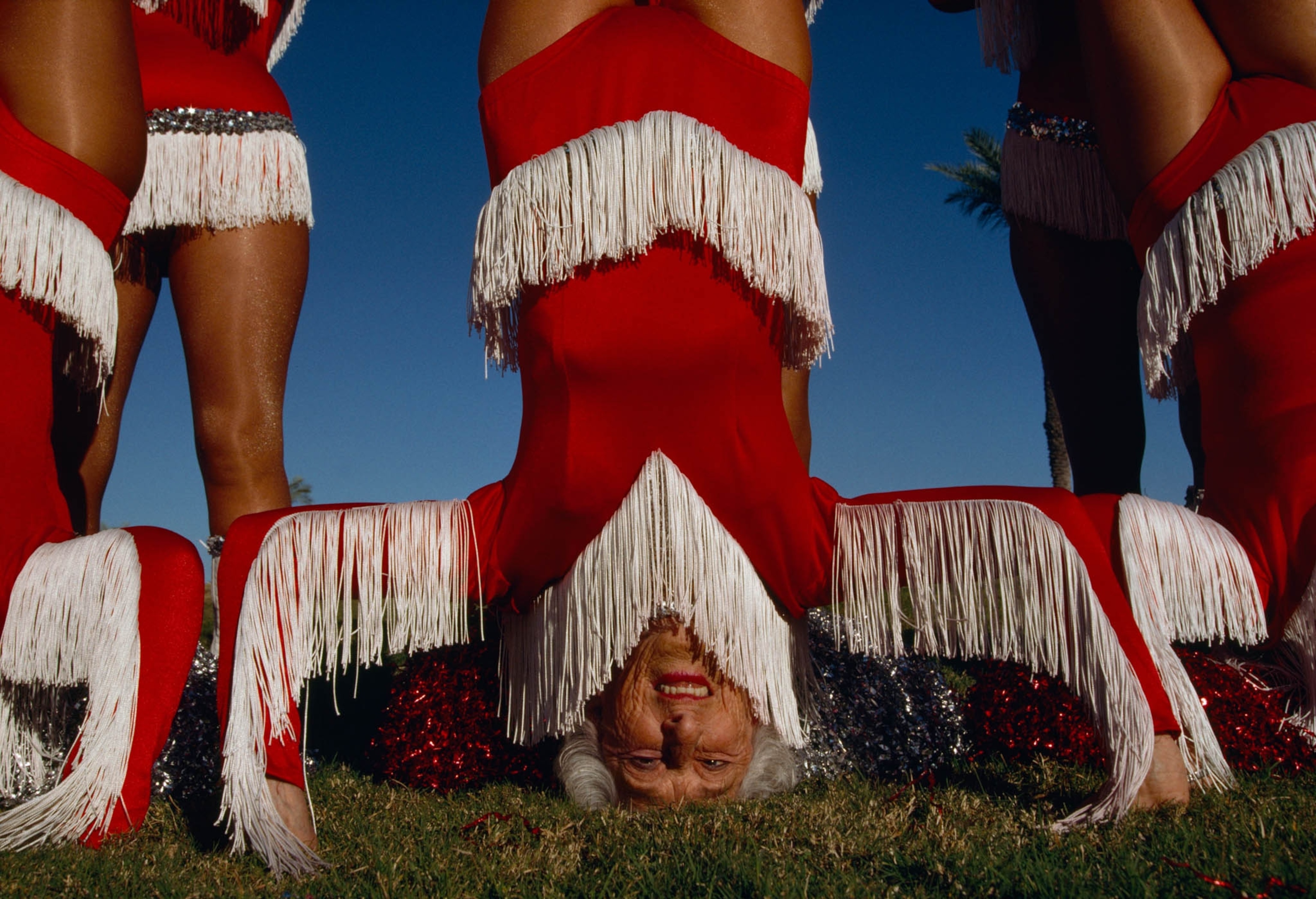 an elderly woman doing a handstand between her dance teammates in Arizona