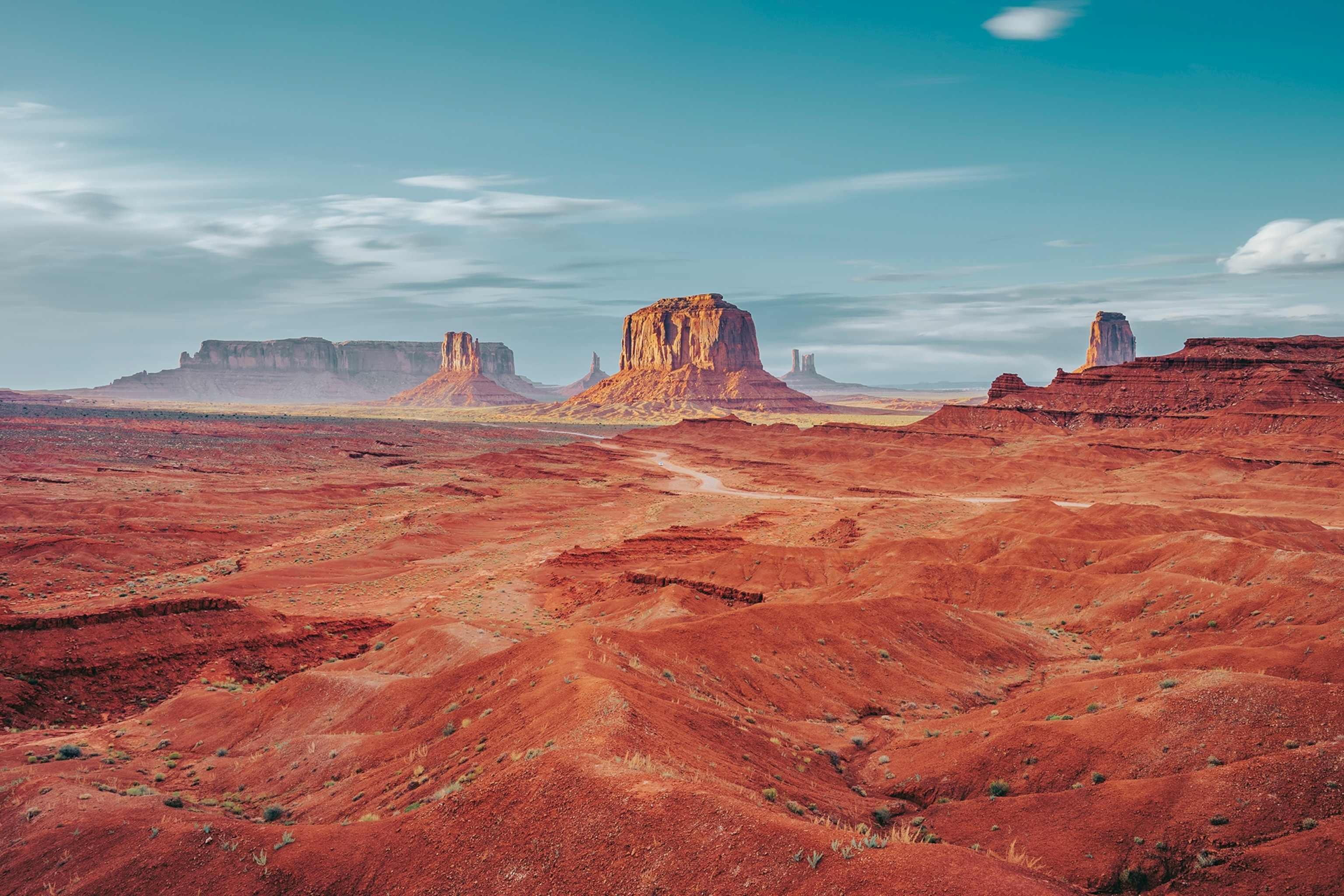 A desert landscape with rock formations scattered in the distance.