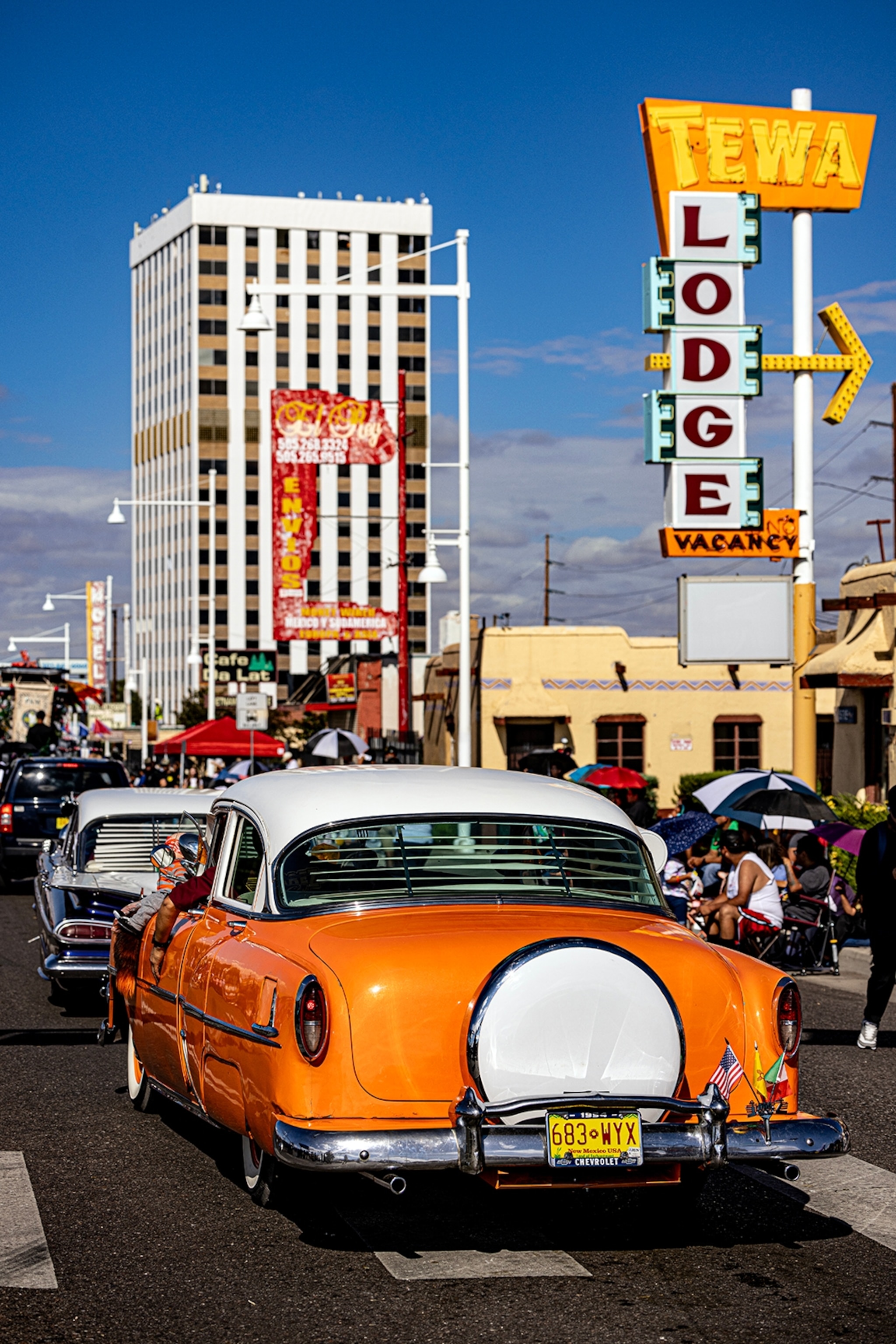 A flashy car cruising down a boulevard with diner signs on either side.