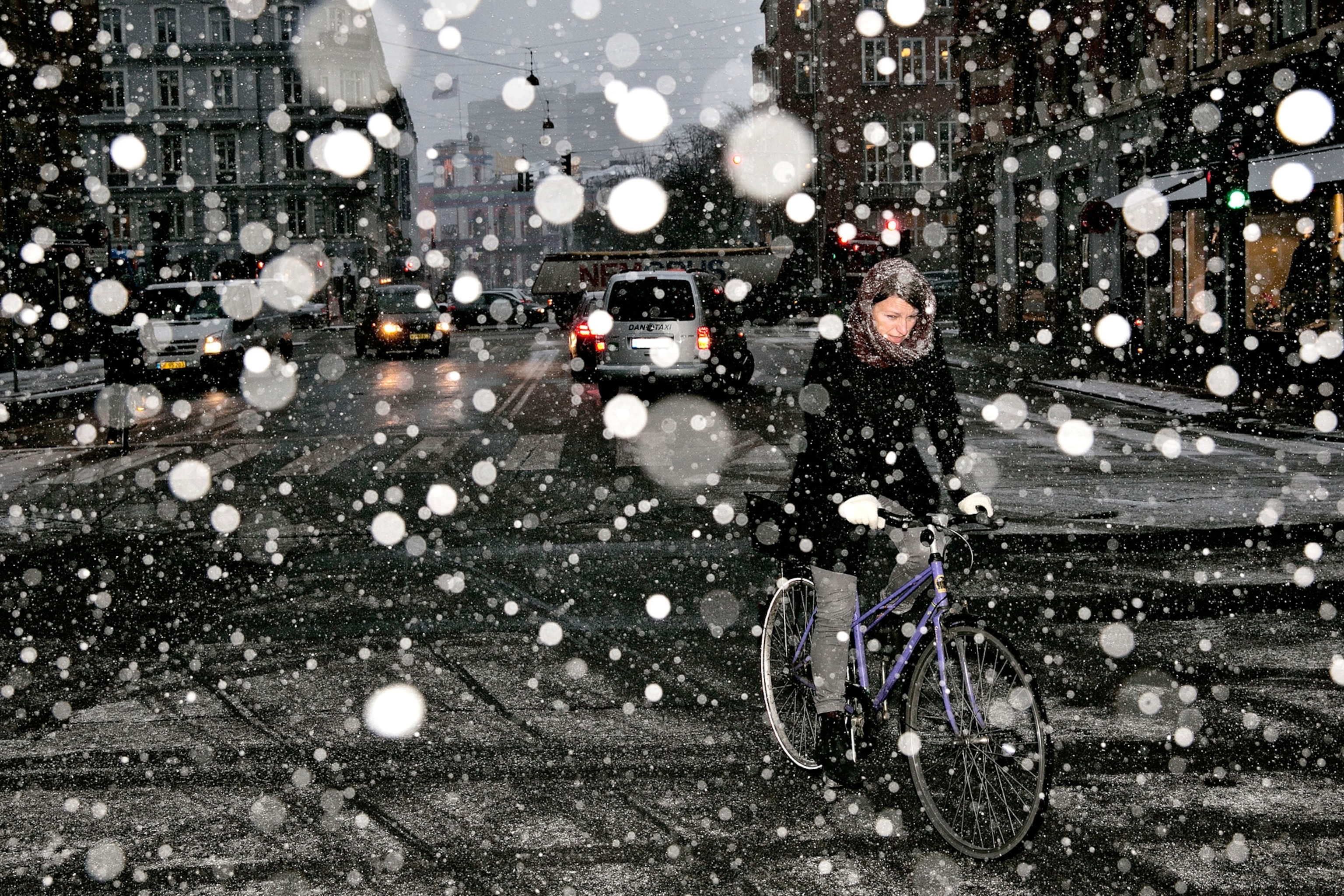 A woman rides a bike on her way to work in heavy snow in Copenhagen, Denmark.