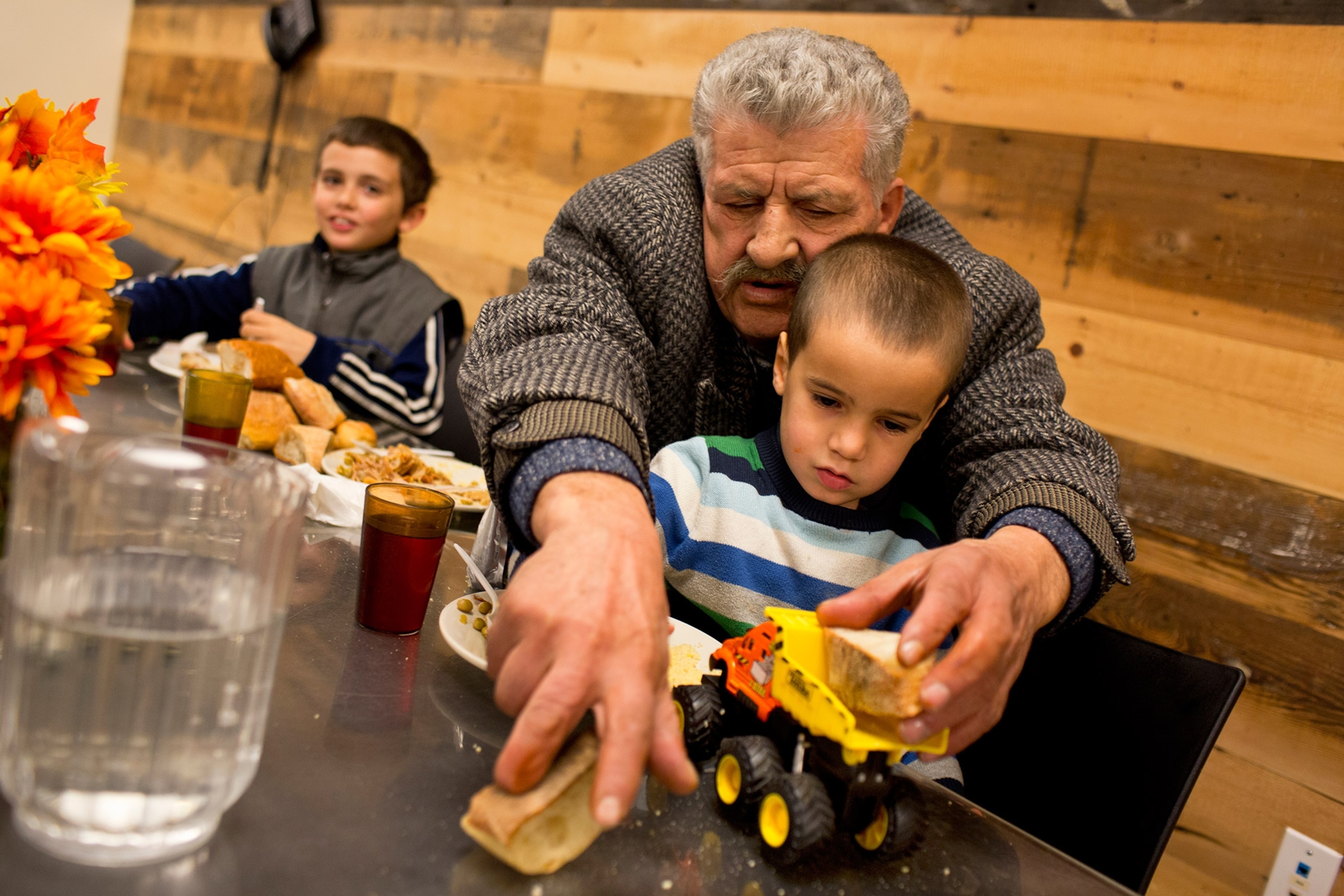 a man playing with his son at the dinner table