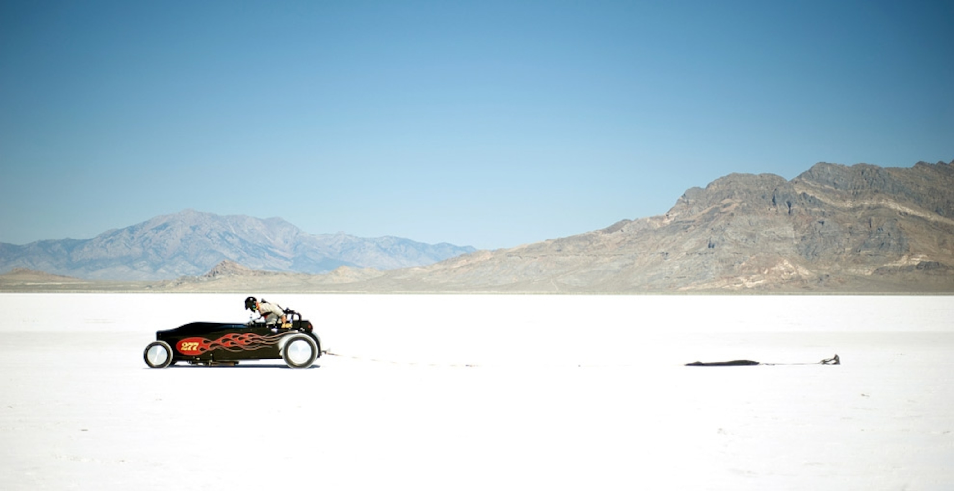 Racer checking his car on a white salt flat