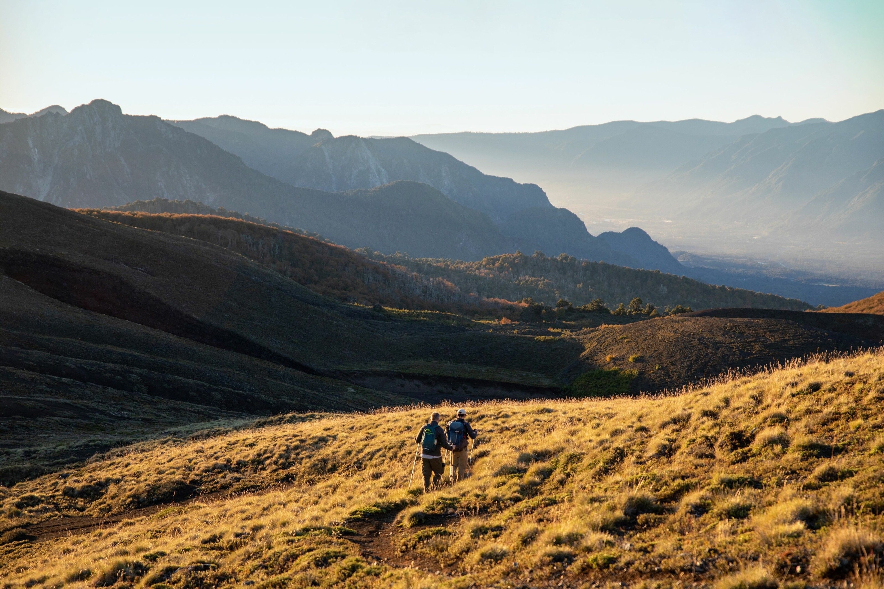 Trekkers make their way downhill as the sun sets.