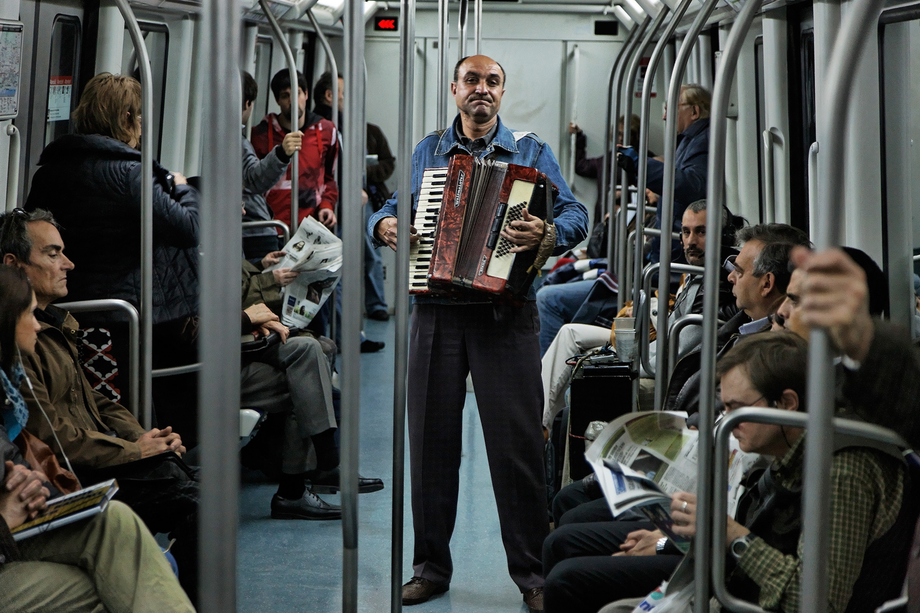 a man playing an accordion on a Barcelona Metro train car