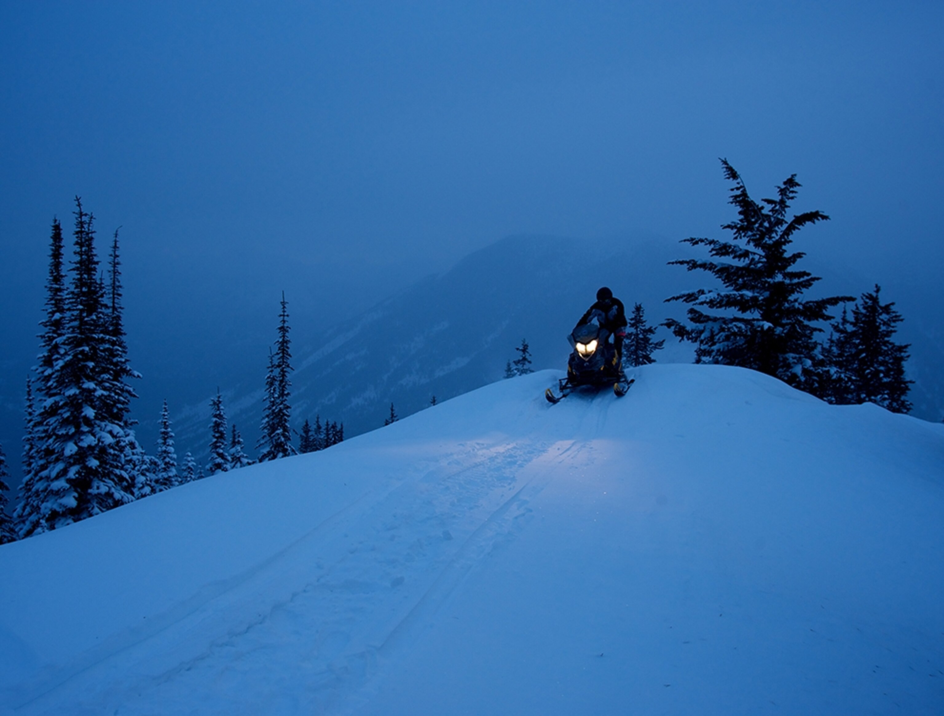 a snowmobiler riding through the snow