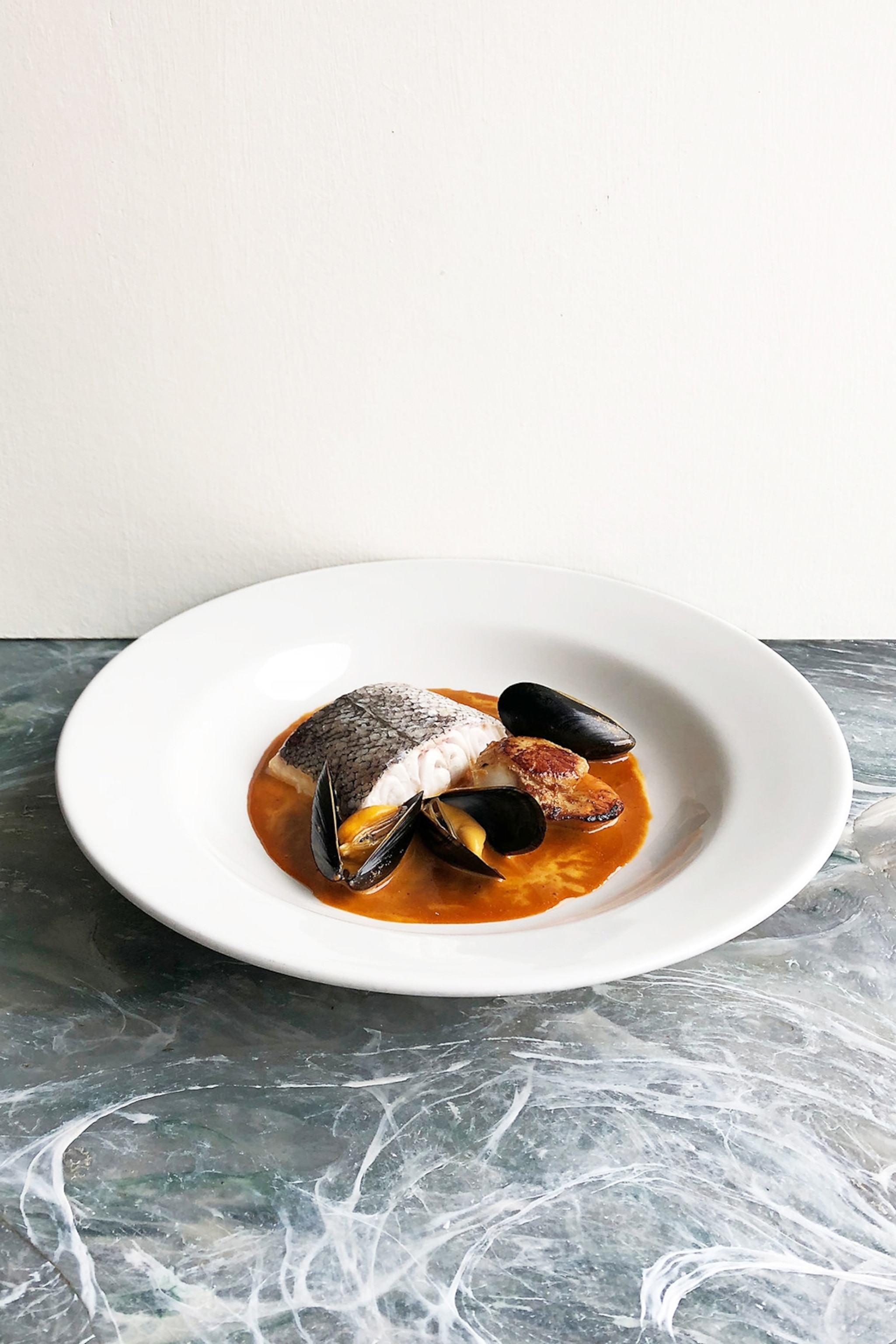 A simple yet elevated plate of steamed hake in a mussel bouillabaisse.