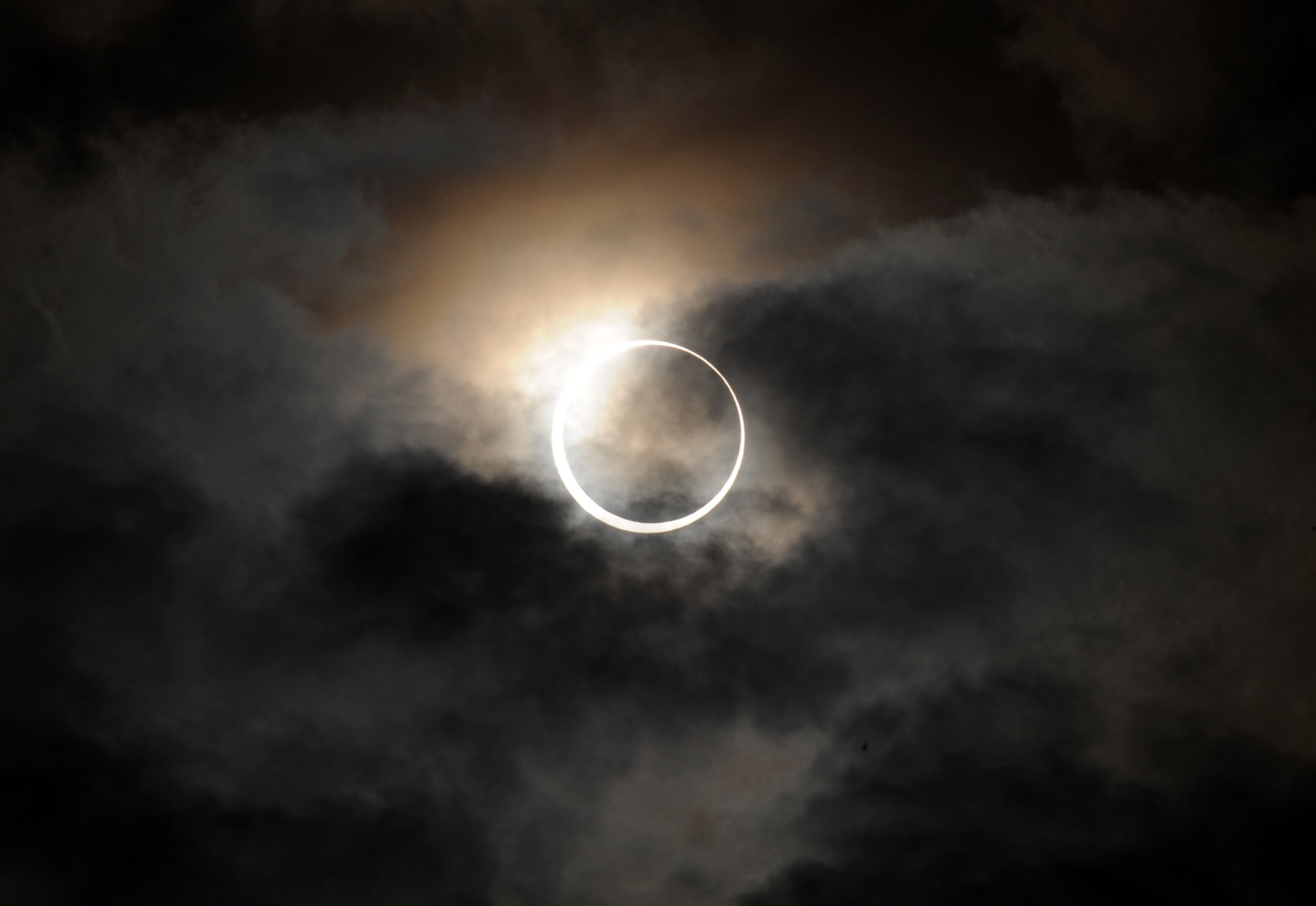 A ring of sunlight during an annular eclipse is seen through clouds.