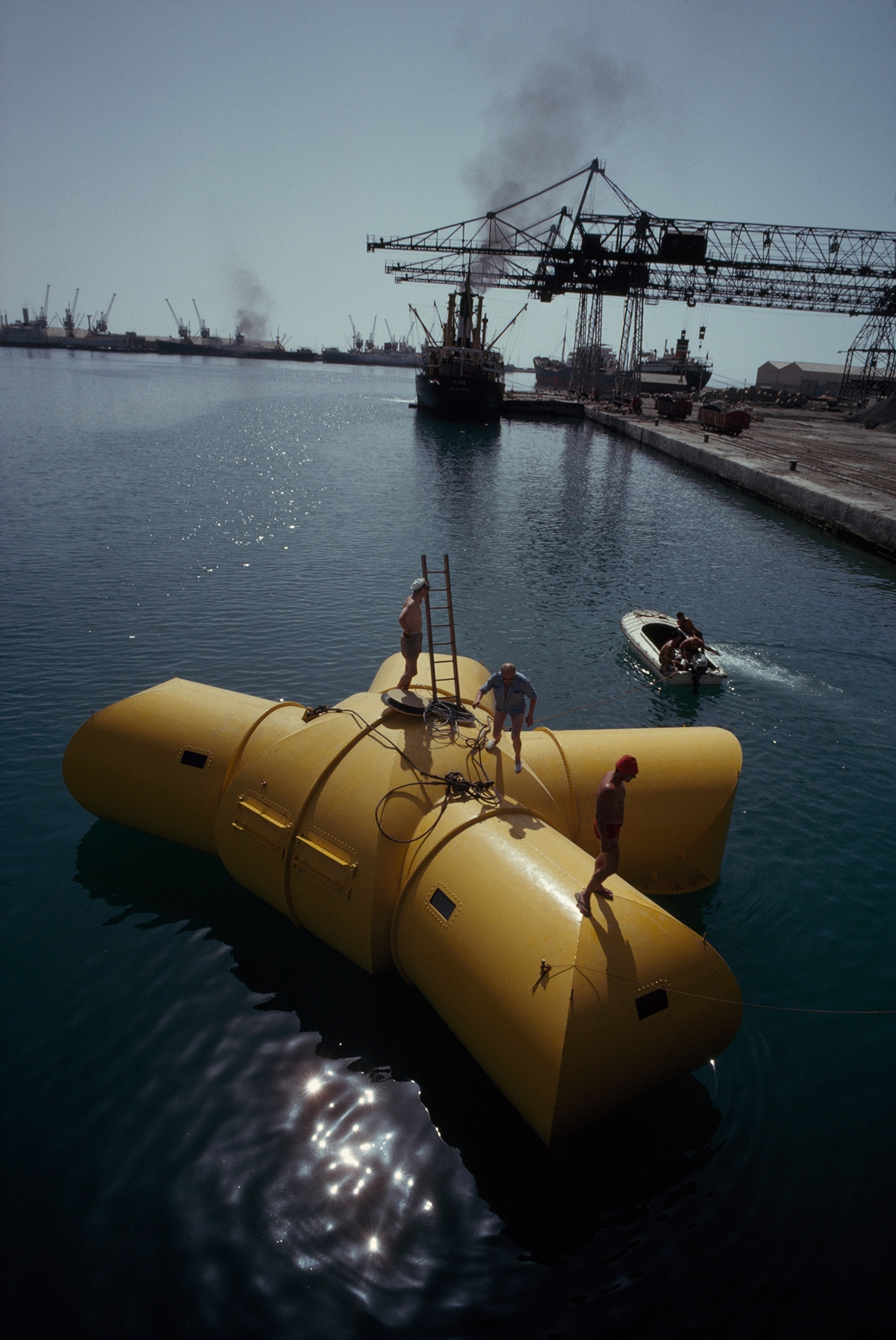 Crew prepare a submersible to be towed and lowered to a coral reef.