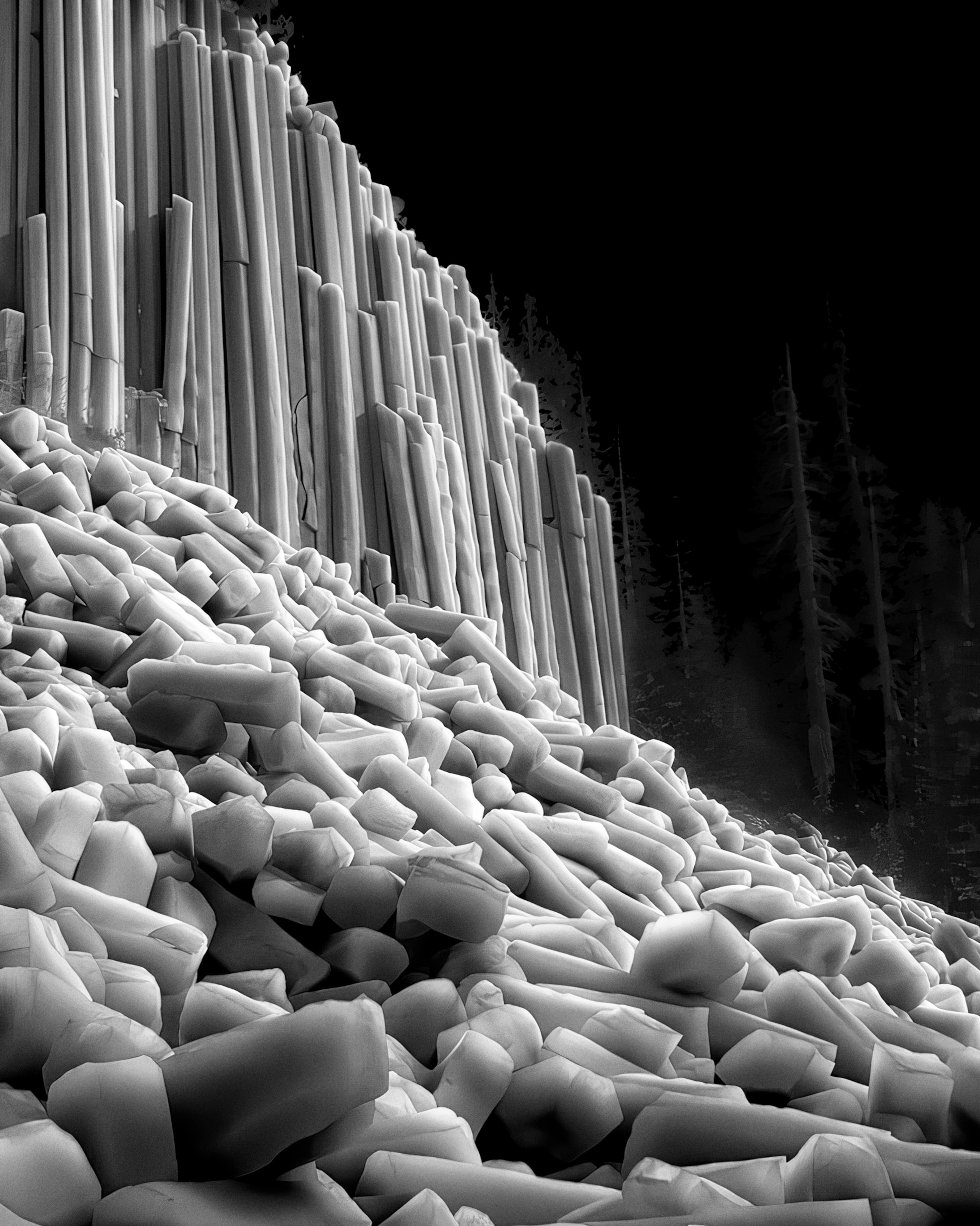 A thermal black and white photo of the Devils Postpile National Monument, with the objects that are the hottest appear brightest, while those that are coldest appear darkest.