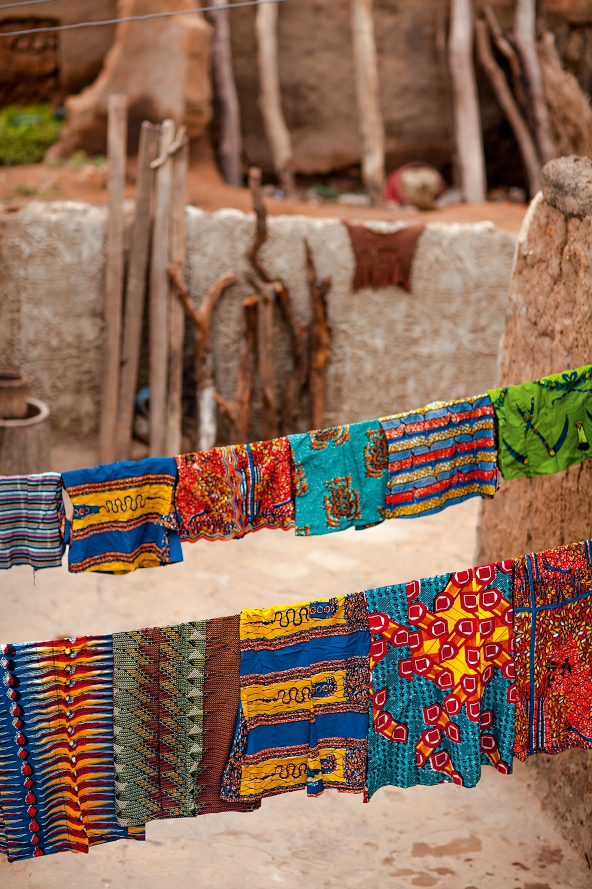 Colourful and patterned fabrics hang on wire lines