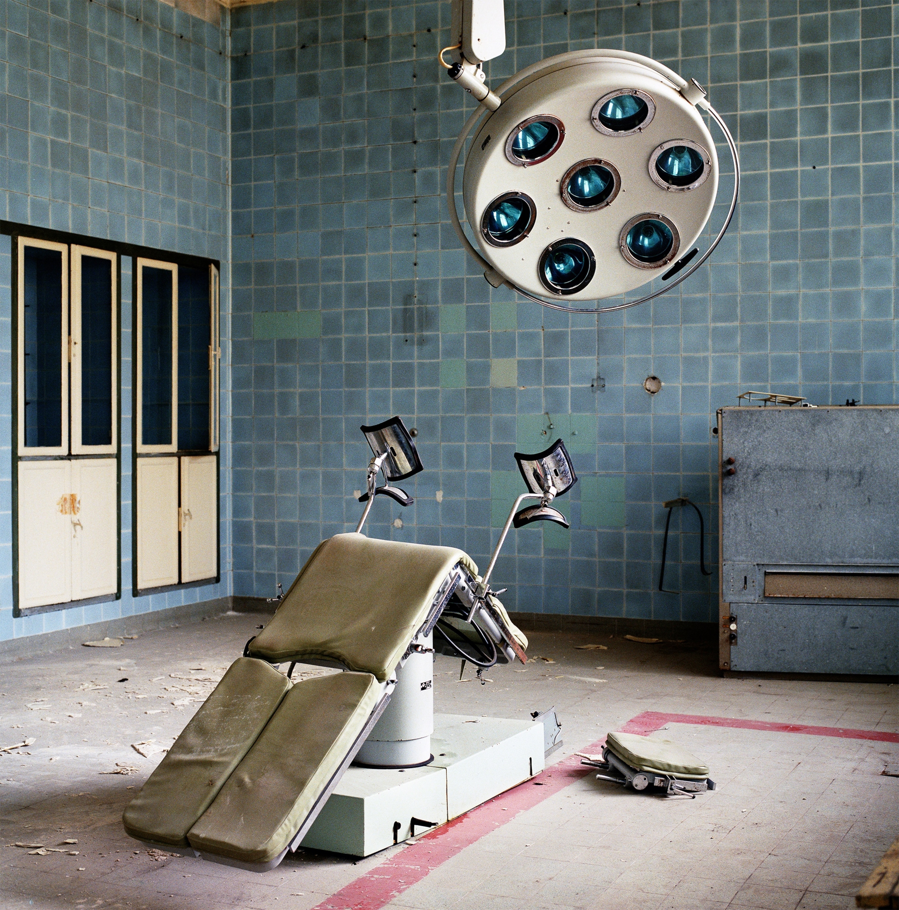 an overturned chair in the operating theatre of a deserted hospital of the Soviet Army.