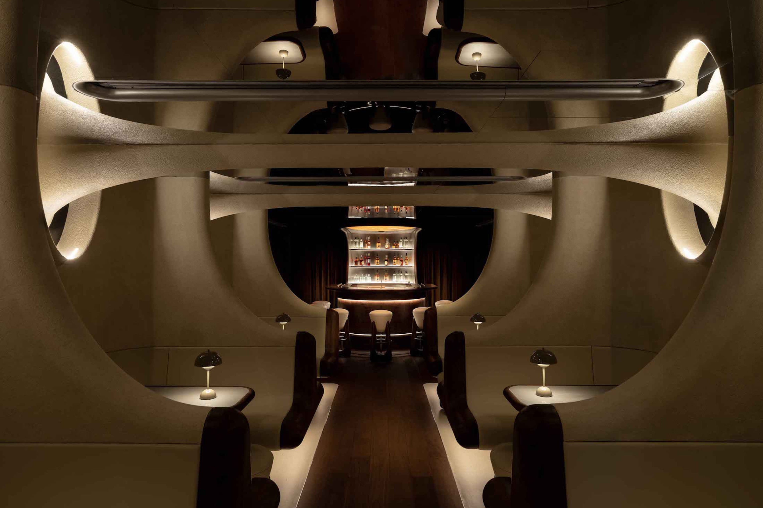 A futuristic, sandstone underground bar with spotlights.