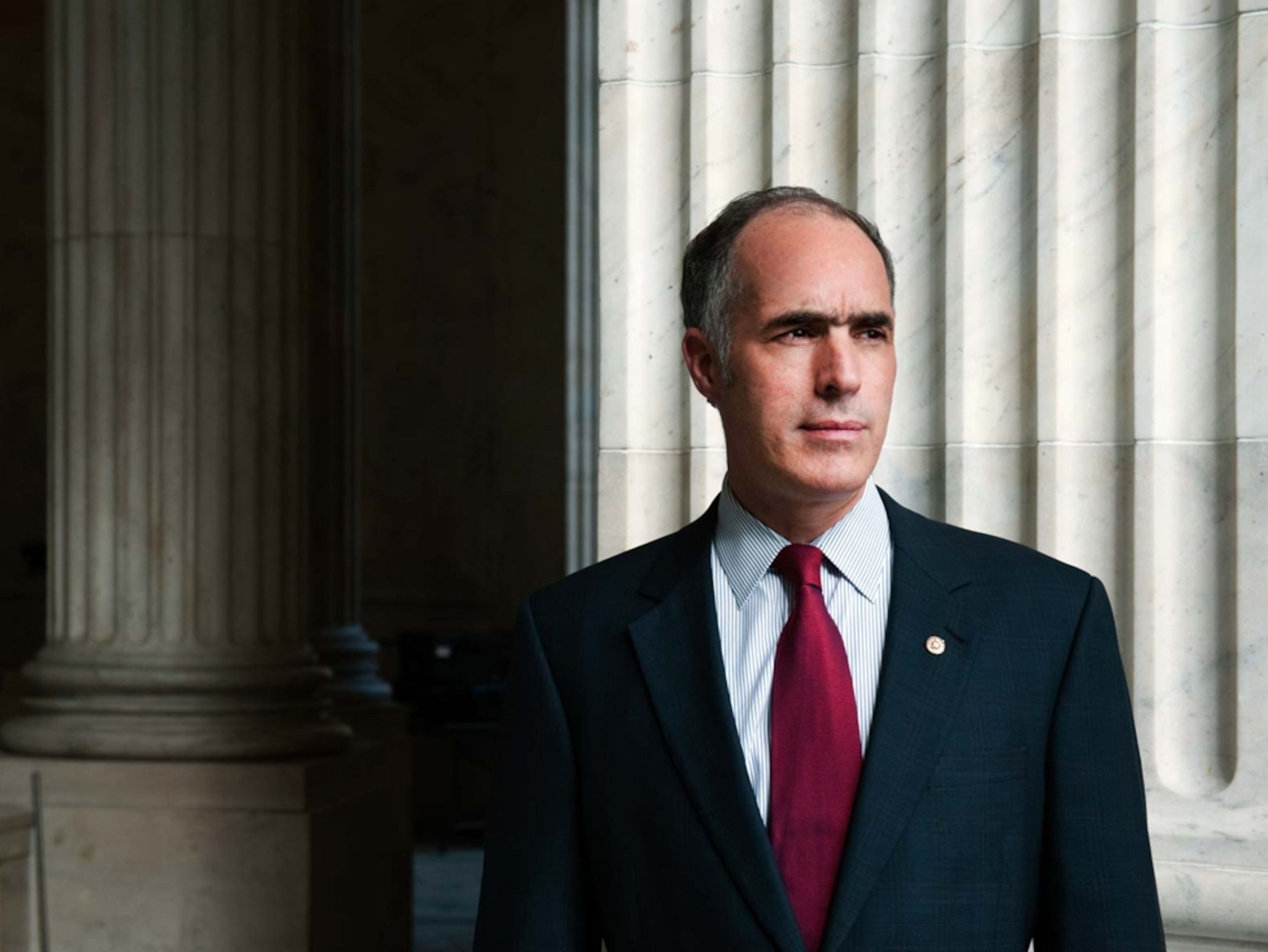 Senator Bob Casey stands before a column in the Russell Senate Office Building.